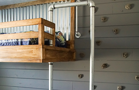 Loft bed with the finished shiplap wall and rock-climbing holds