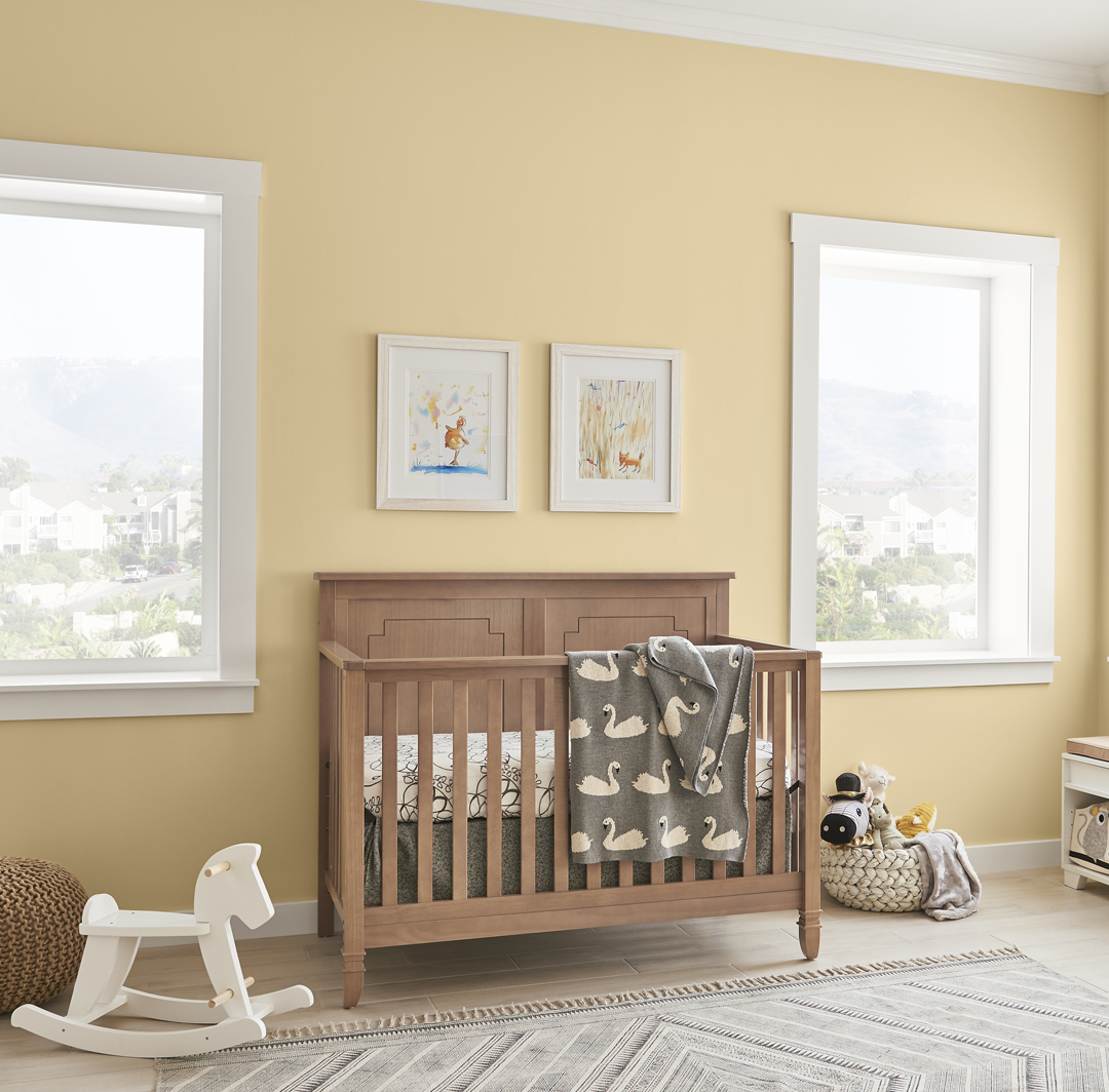 Inspirational youth nursery room small image with yellow wall and white trim, brown wooden crib with white rocking horse.