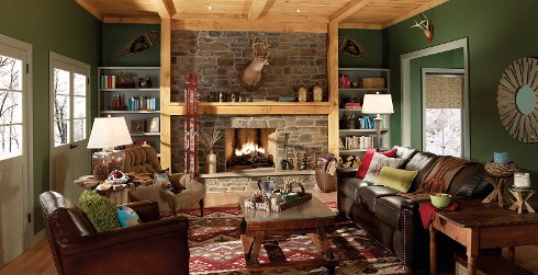 Cottage living room with olive green on walls, light gray on trim and doors, leather couch and chair, and brick fireplace