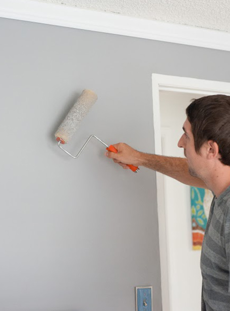 man painting wall grey