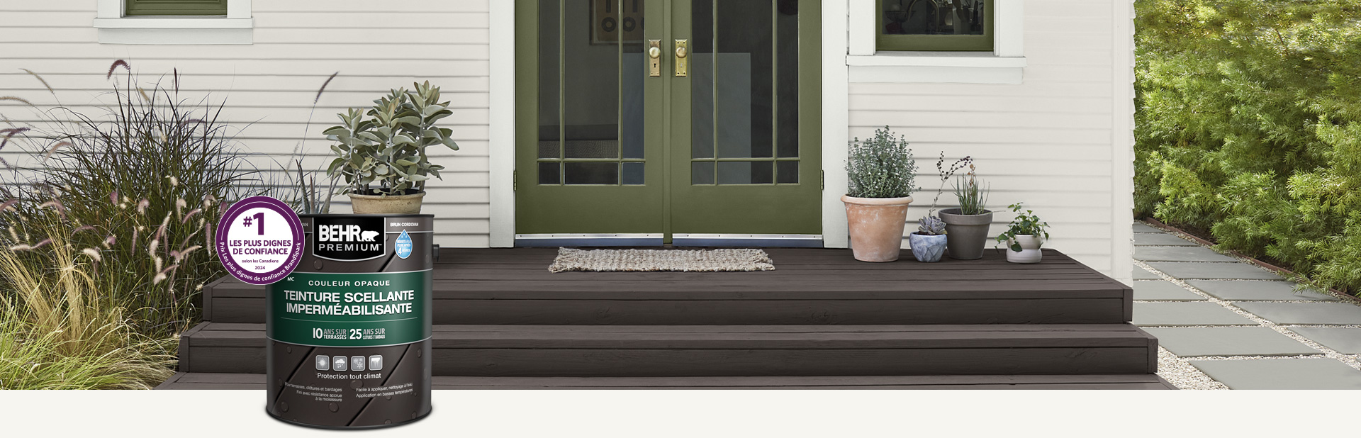 Un contenant de teinture semi-transparente pour bois Behr Premium avec une terrasse en bois en arrière-plan