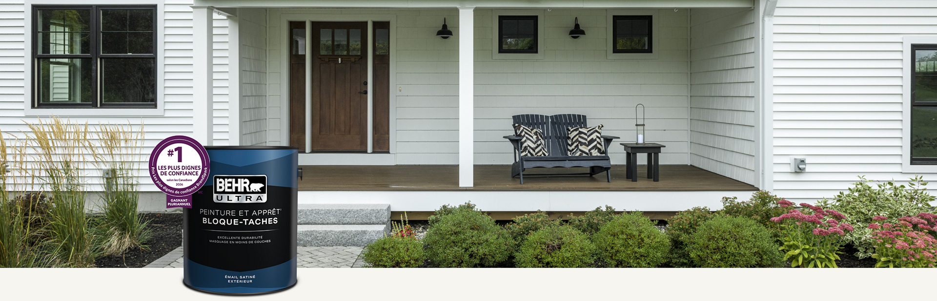 Extérieur de maison blanche avec un contenant de peinture extérieure Behr Ultra émail satiné au premier plan