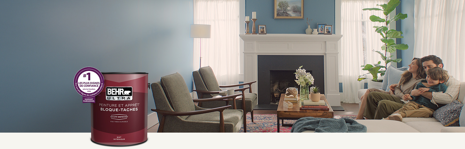 Salon avec un mur de couleur pêche pâle et un contenant de peinture intérieure mate Behr Ultra au premier plan