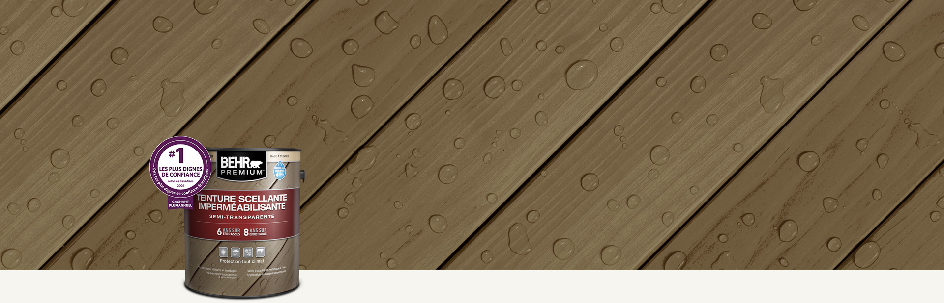 Un contenant de teinture semi-transparente pour bois Behr Premium avec une terrasse en bois en arrière-plan