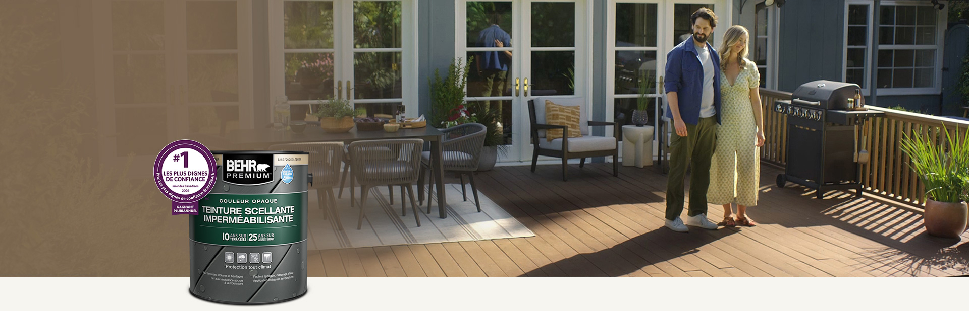 Un contenant de teinture semi-transparente pour bois Behr Premium avec une terrasse en bois en arrière-plan