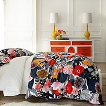 Bedroom with floral comforter on bed and orange dresser