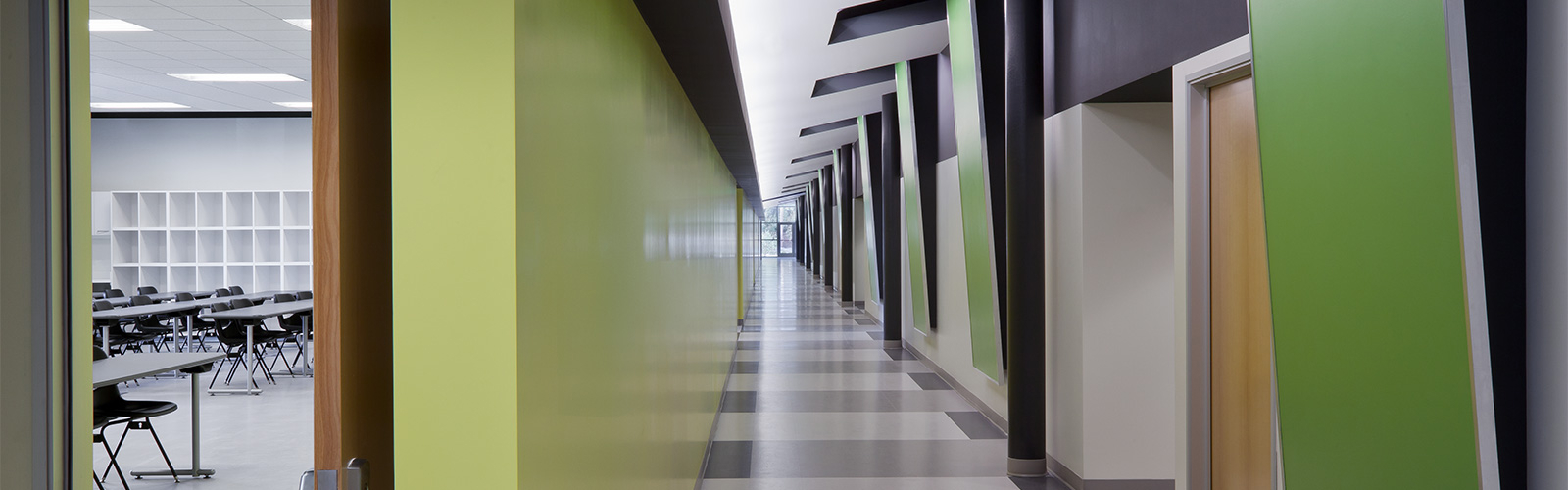 An image of a large empty classroom hallway with a green, gray and white colour combination.