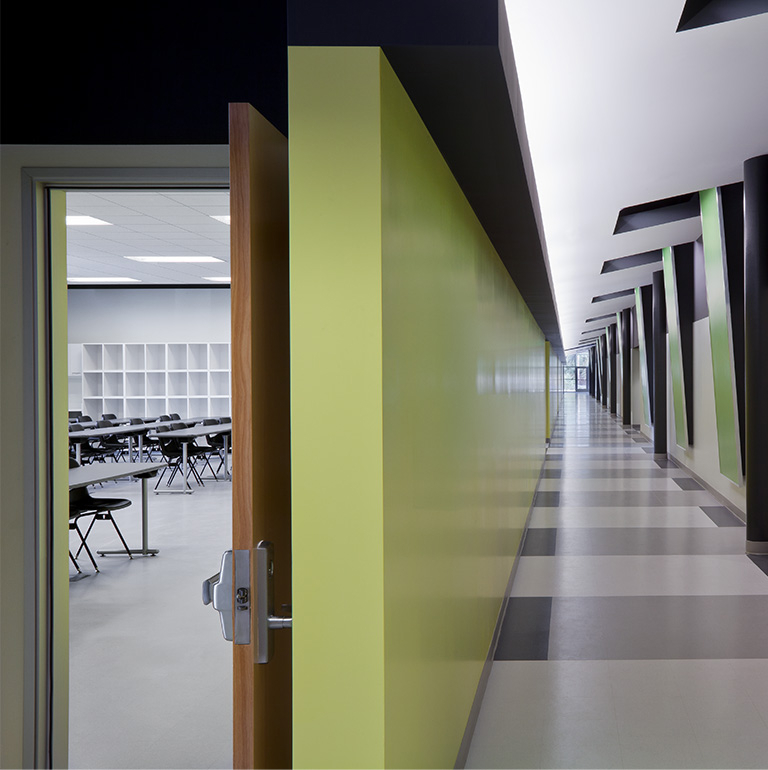 An image of a small empty classroom hallway with a green, gray and white colour combination.