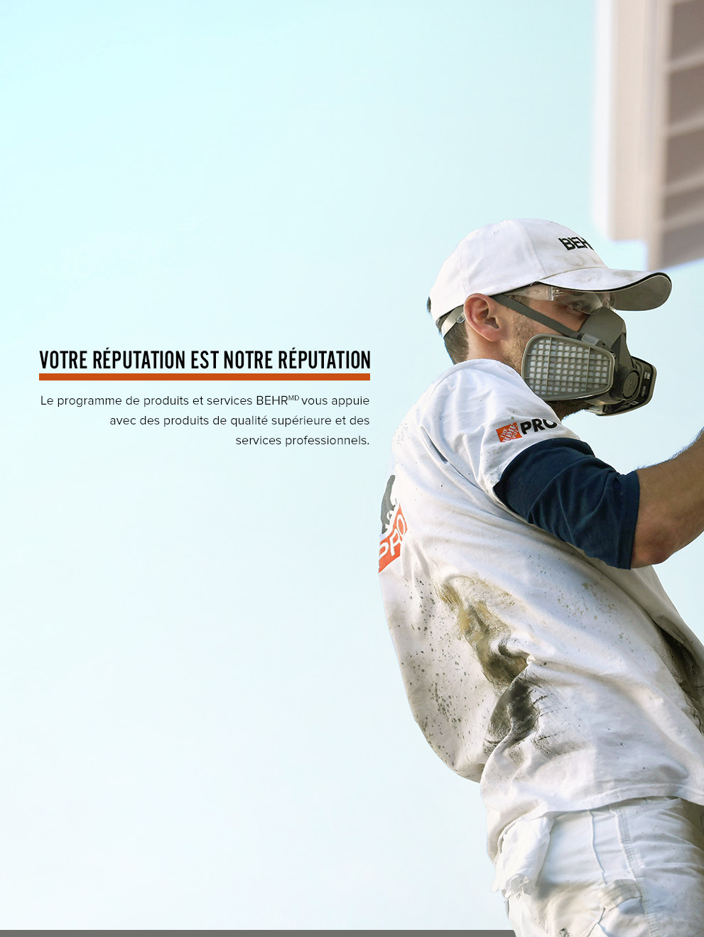 Mobile view of an Image of a Pro Contractor wearing a hat and shirt with Behr logo spray painting an exterior wall of a house on a ladder.