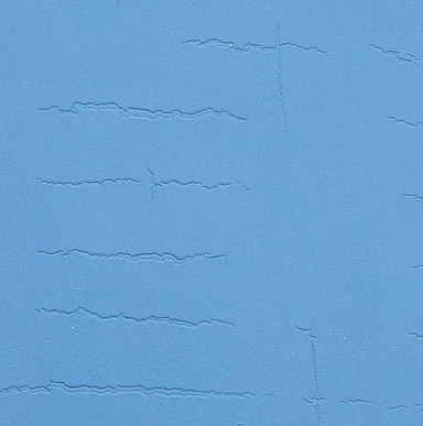 Close up image of a surface that has deep, irregular cracks resembling dried mud.