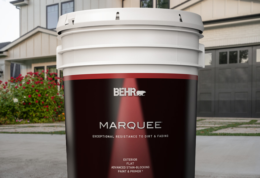 Image of a 5 gallon can shot of BEHR MARQUEE in front of a house.