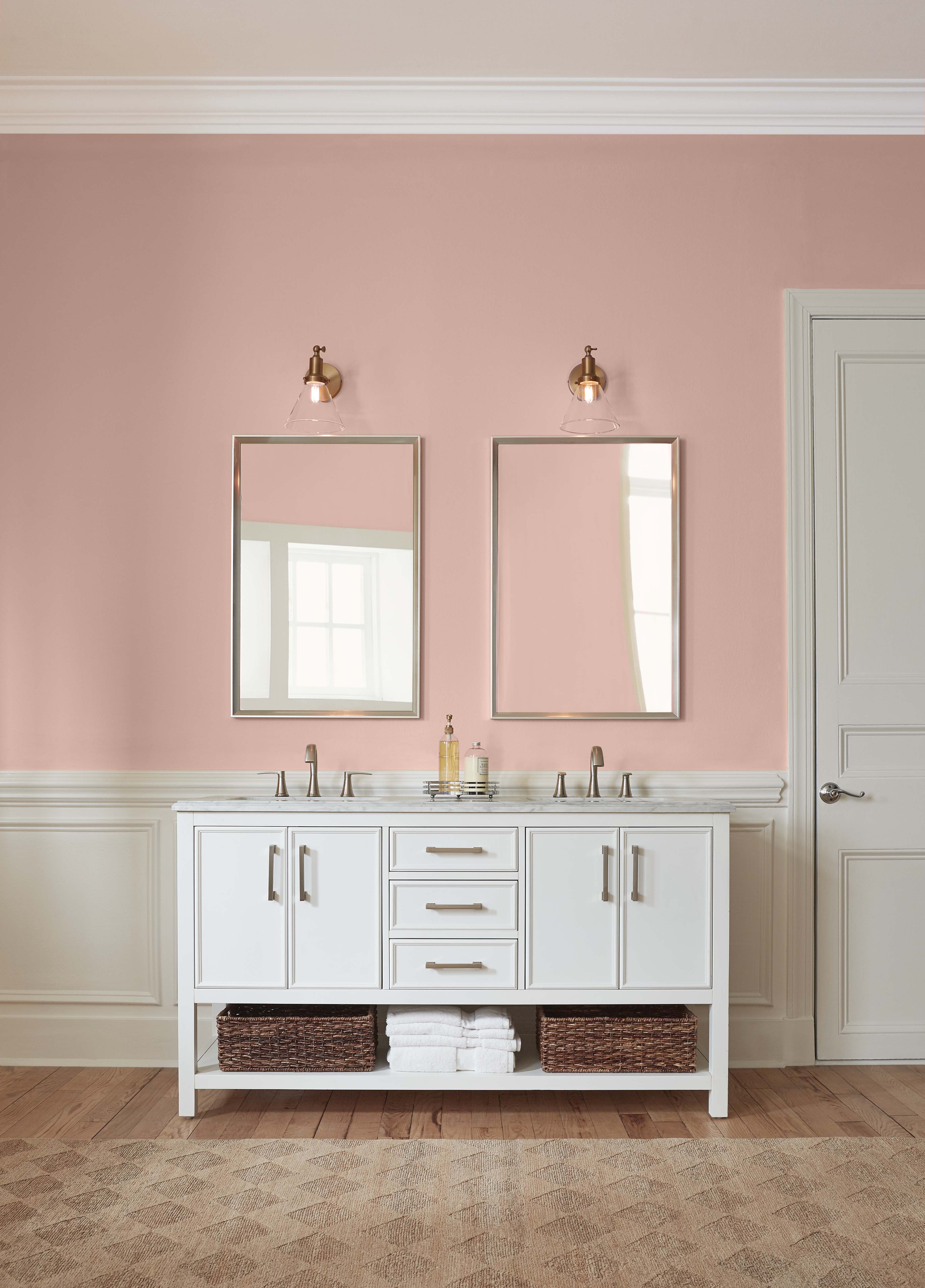 Une salle de bain classique avec lavabos pour elle et lui, la couleur du mur est un rose clair.