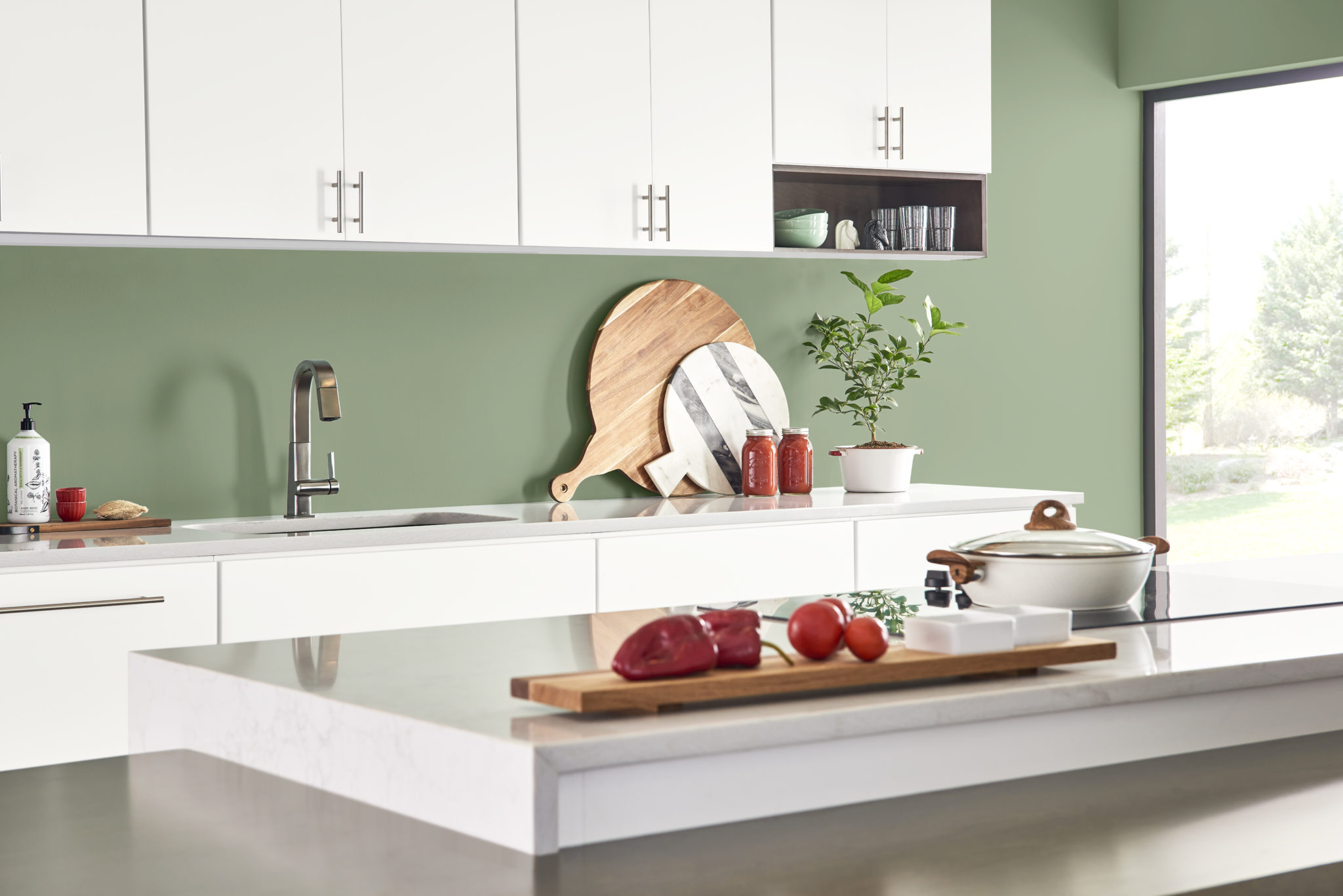Une cuisine moderne et décontractée avec des armoires blanches. La couleur de la peinture du dosseret s'appelle Arbre de lauriers.