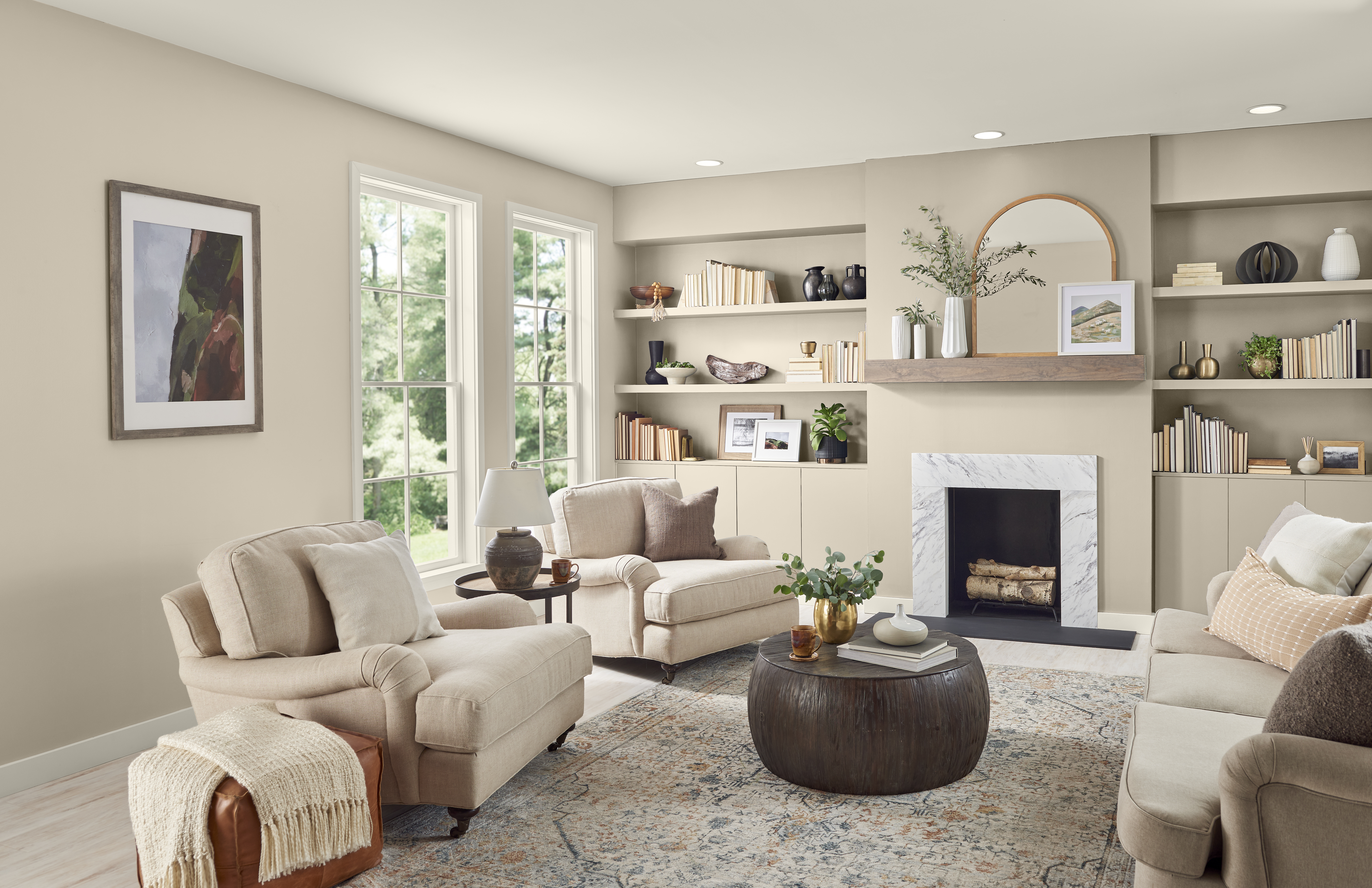 Un salon confortable aux murs et étagères intégrées peints en Encore plus beige, meublé de neutres assortis.