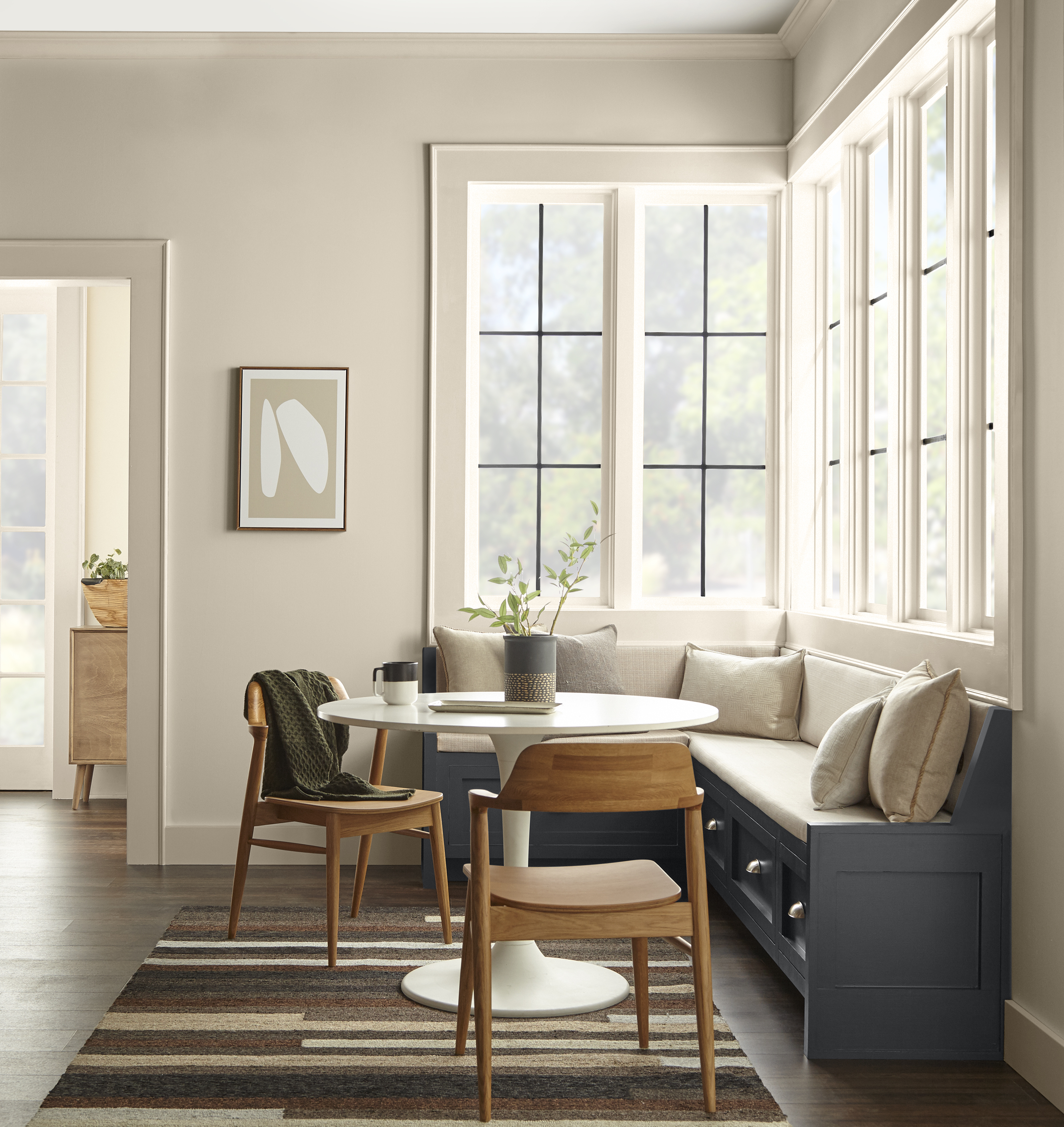 Un coin cuisine avec des murs peints en Encore plus beige et une banquette peinturée en un gris foncé contrastant.