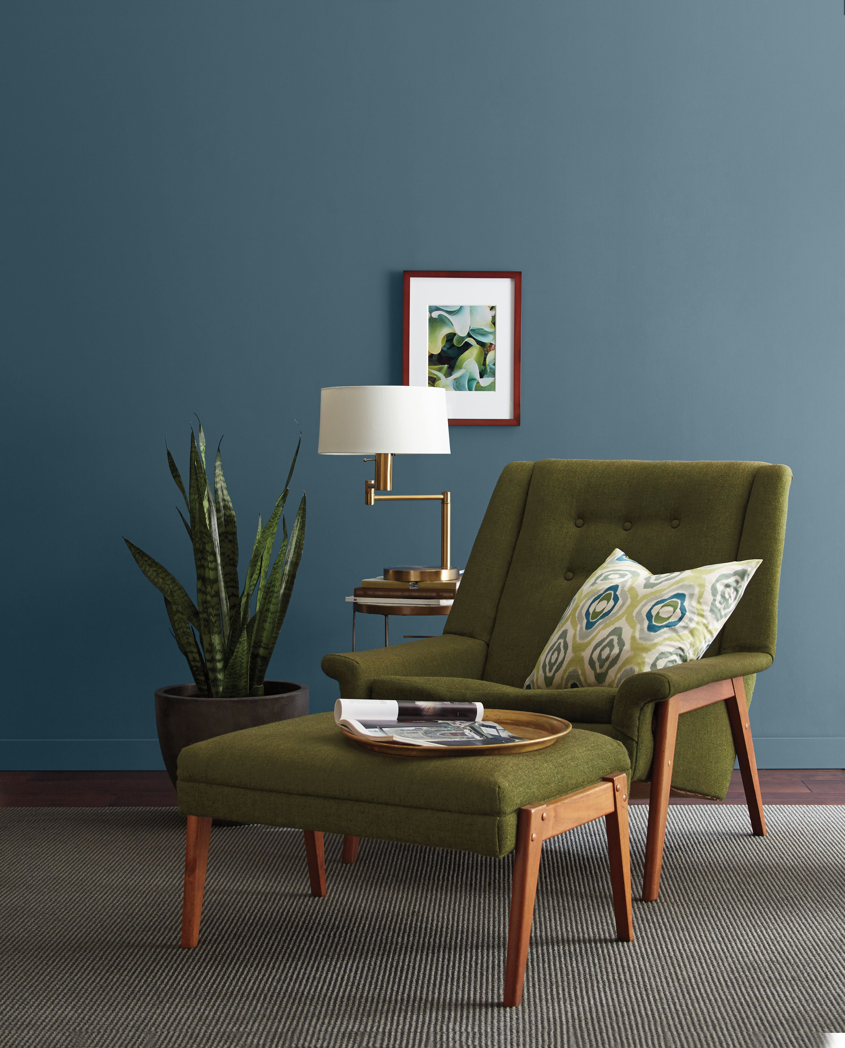 Mur peint en bleu foncé, agencé avec une chaise rétro vert olive et des éléments de décoration