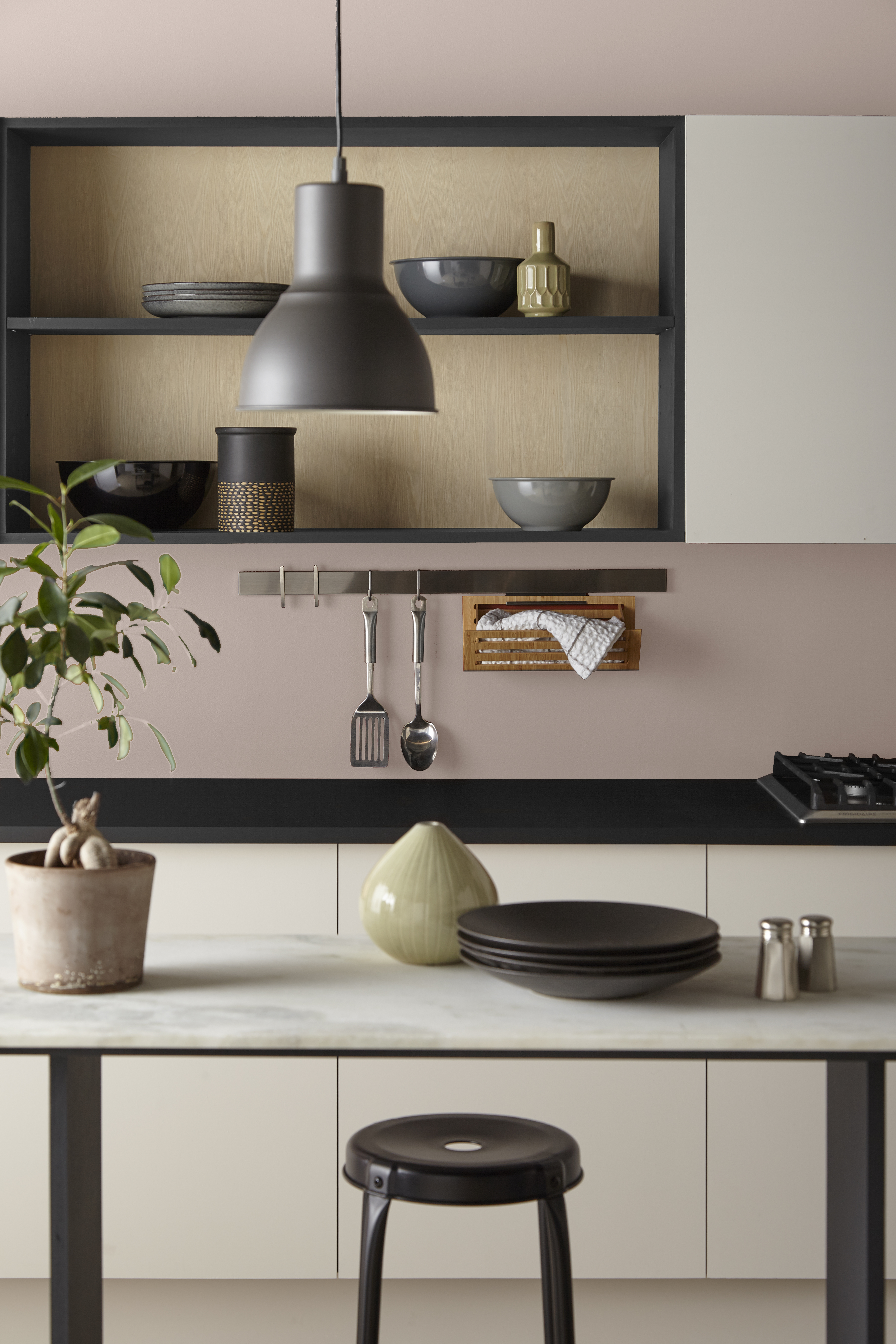 Une cuisine moderne avec des murs peints en Rose fumé et des armoires et garnitures blanches et noires contrastantes