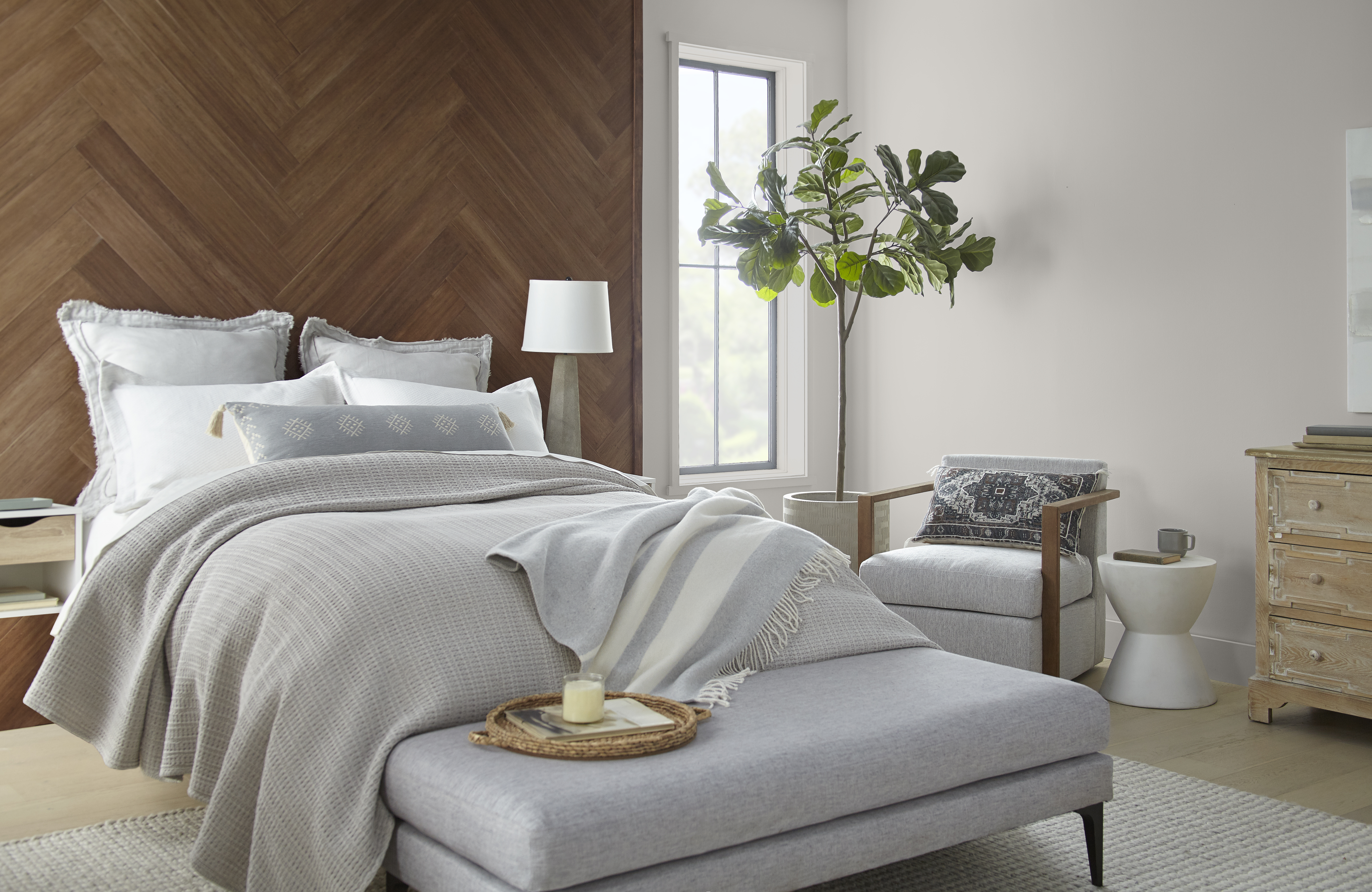 Une chambre à coucher avec une tête de lit en bois et des murs latéraux peinturés en un grège clair