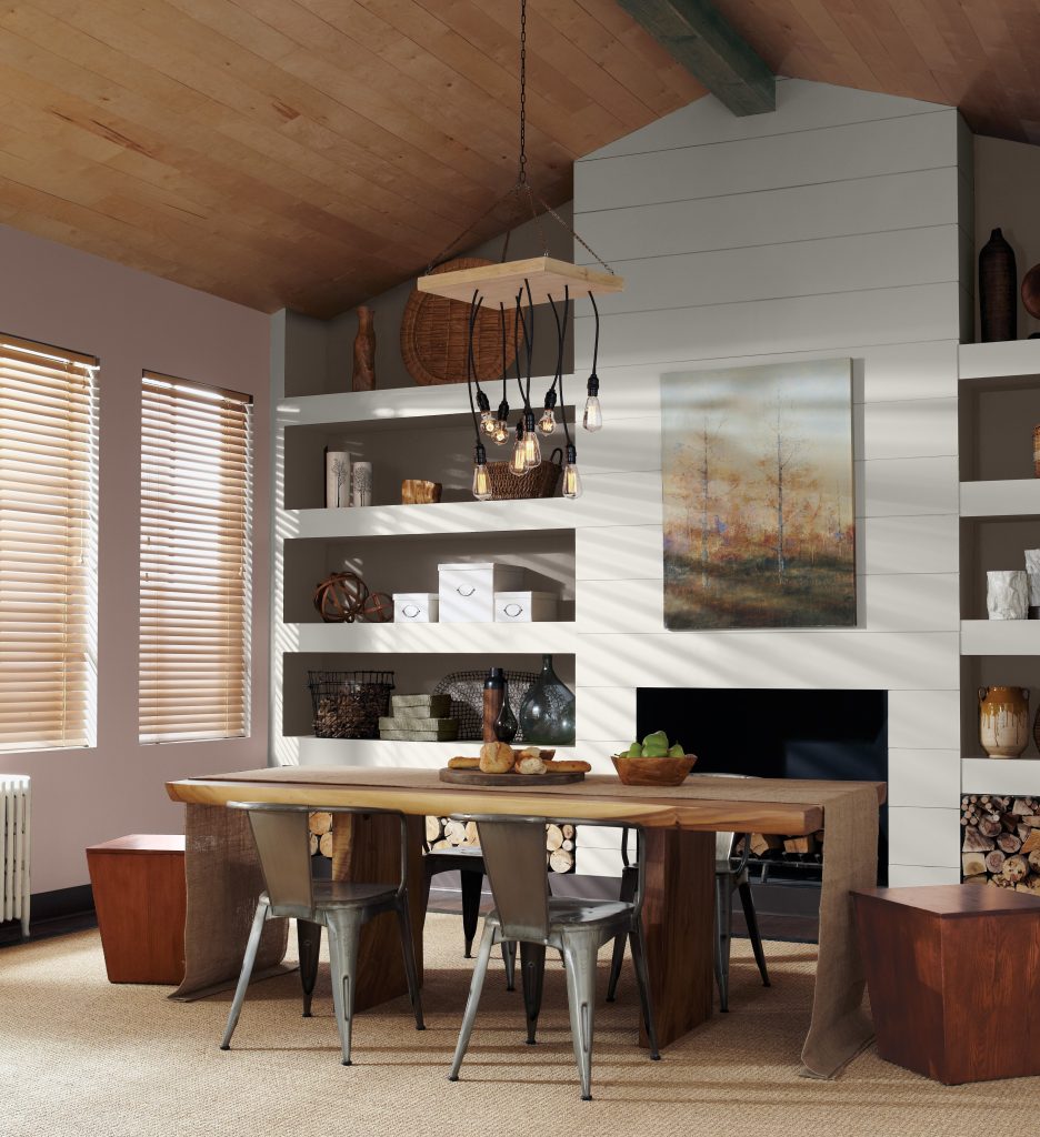 Une salle à manger avec de hauts plafonds en bois, avec un mur peinturé en Envie cacao et l'autre en Blanc studio.