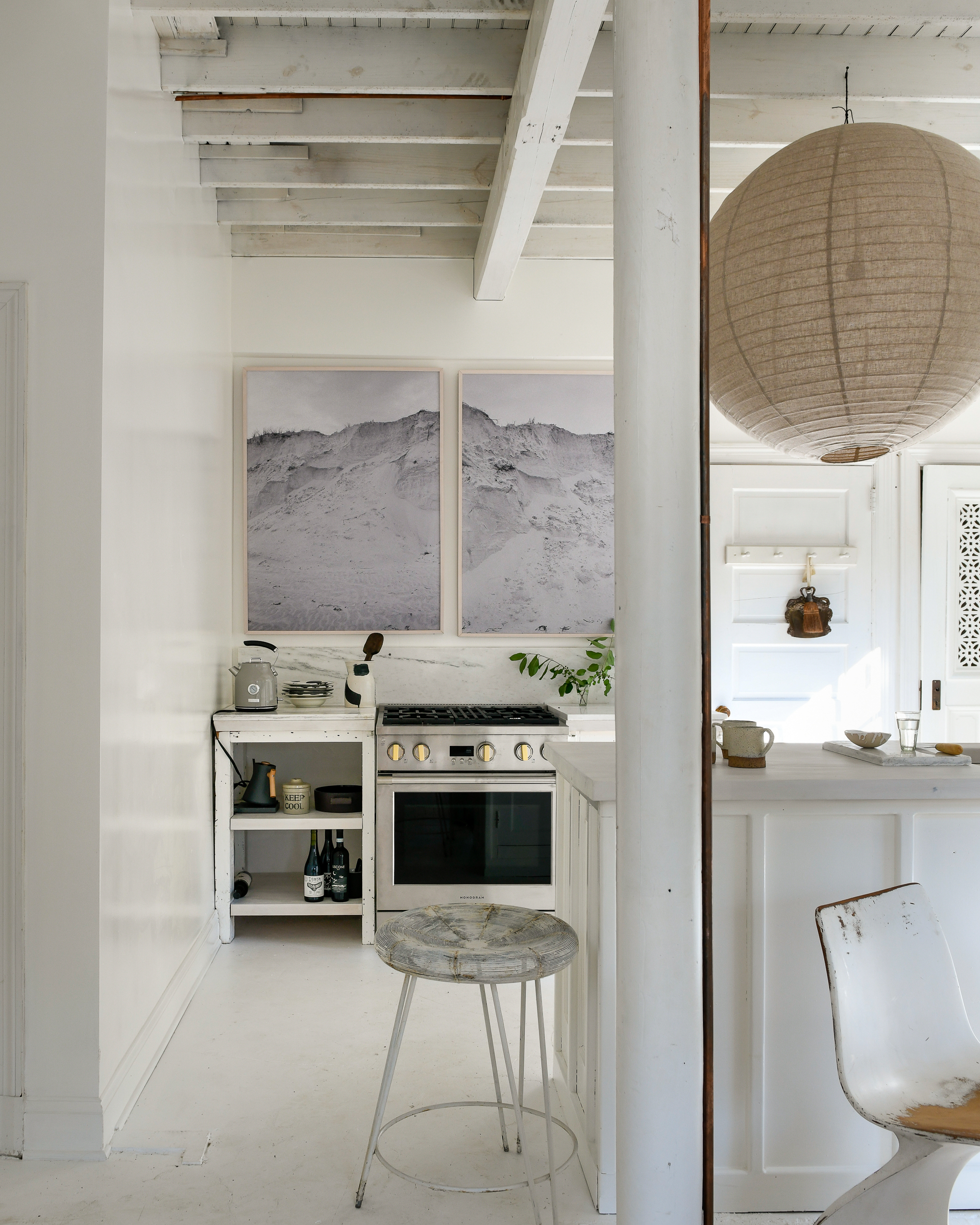 La cuisine simple et lumineuse de Leanne Ford, dont les murs sont peints en Blanc naturel et décorés de grands tableaux d'art en gris