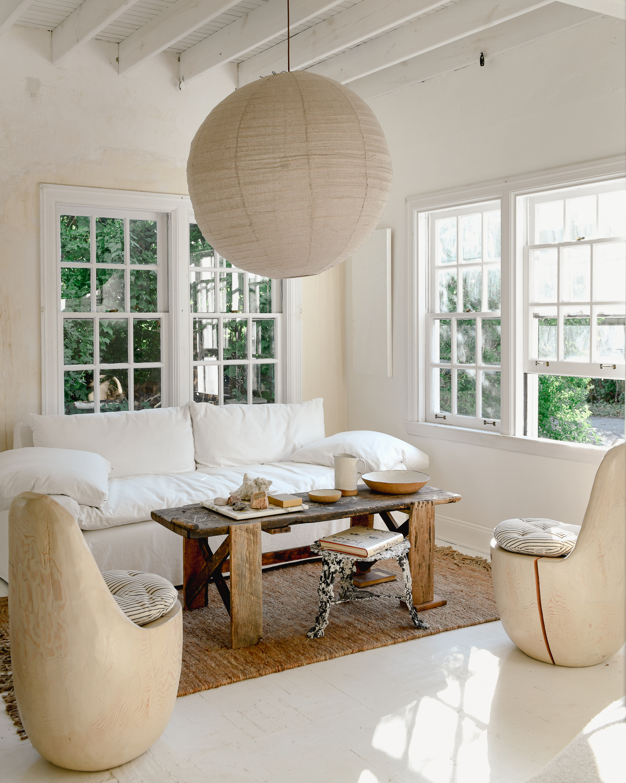 Le salon de Leanne Ford aux murs peints en Blanc naturel et aménagé avec des meubles et accessoires dans des tons de blanc et de beige