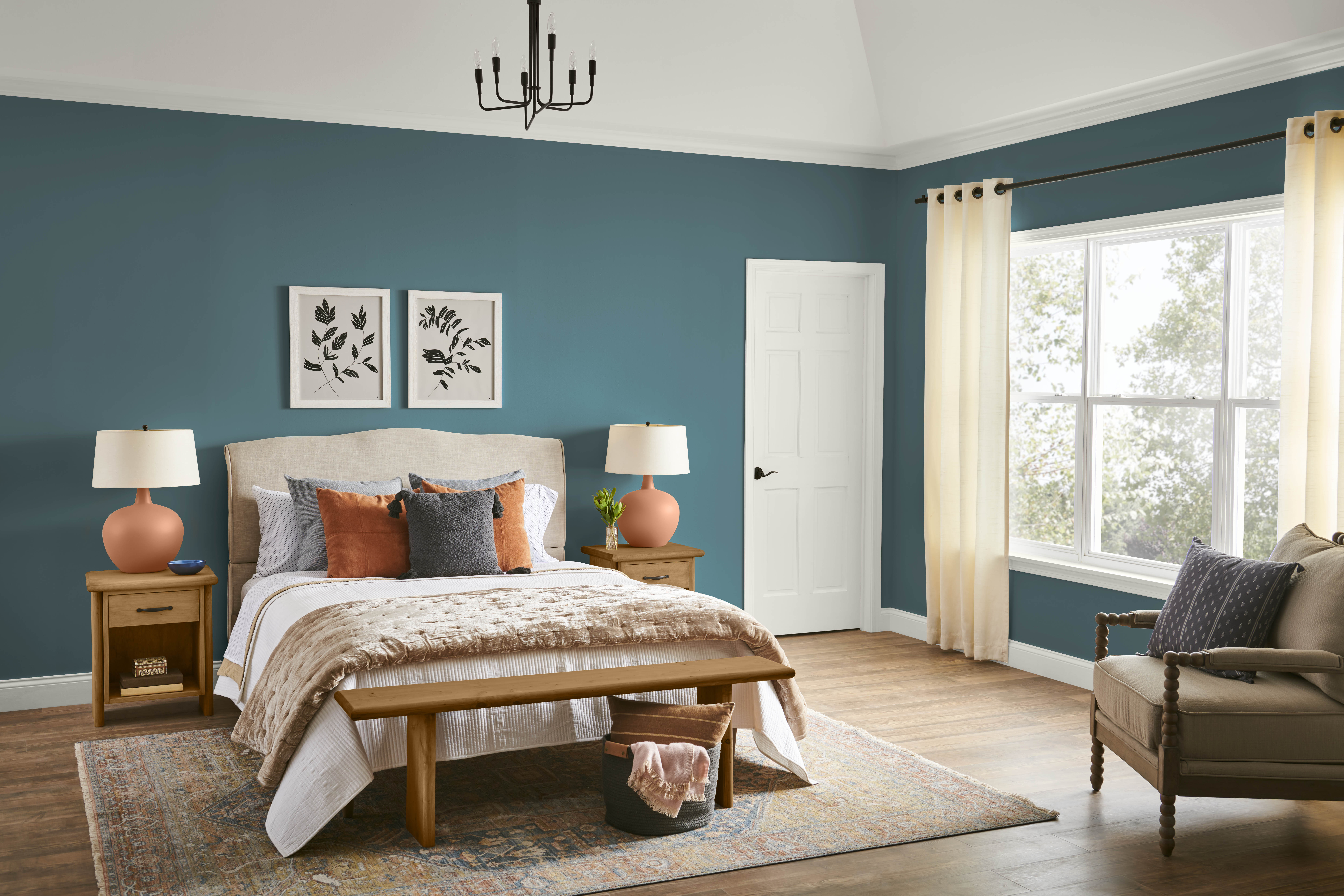 Une chambre à coucher avec des murs dans la couleur Sarcelle sophistiquée, stylisée avec des meubles et accents aux teintes neutres et de terre cuite