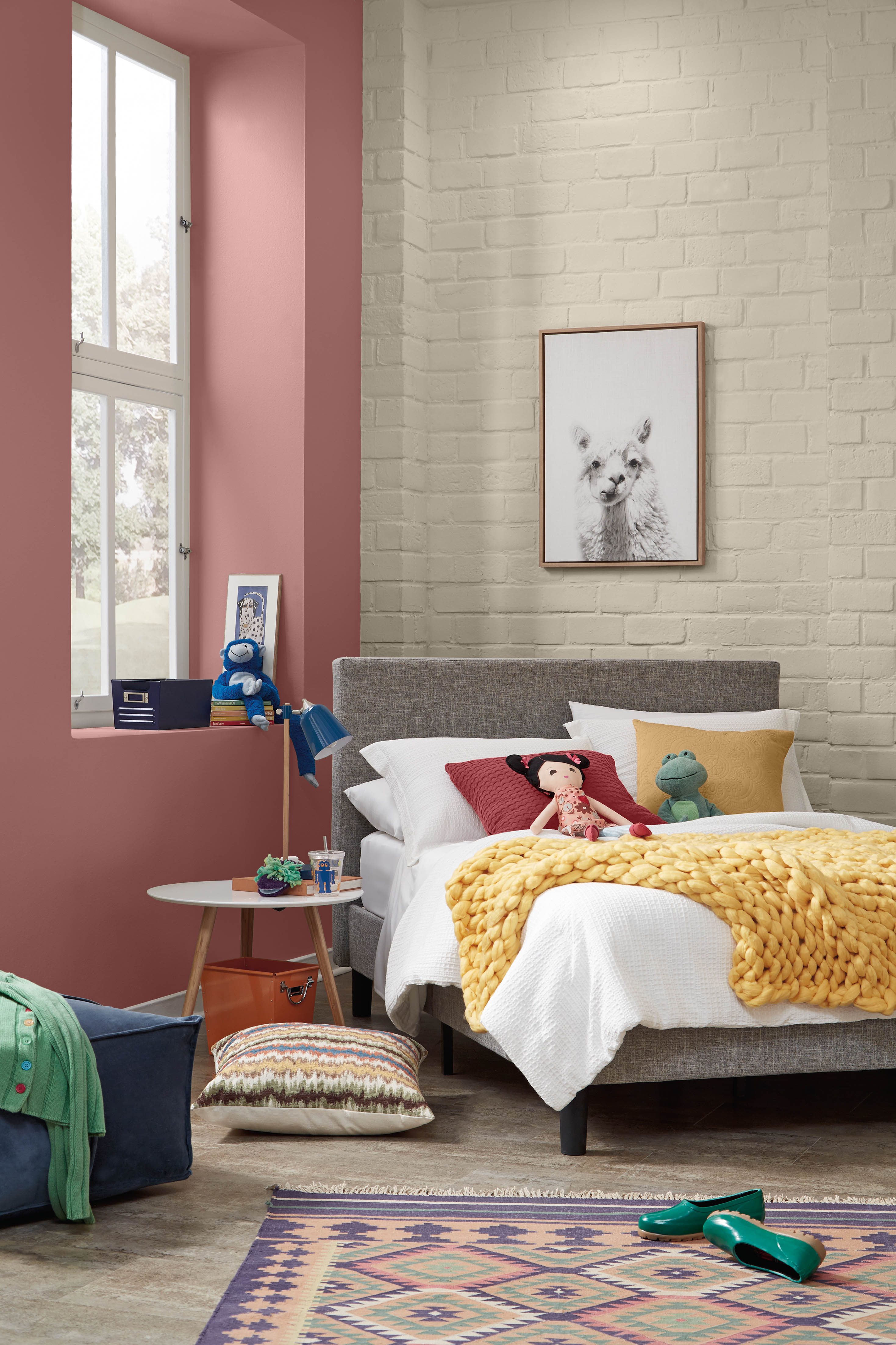 Une chambre d'enfant avec un mur de briques dans la couleur Encore plus beige et un mur d'accent dans la couleur Vermillon