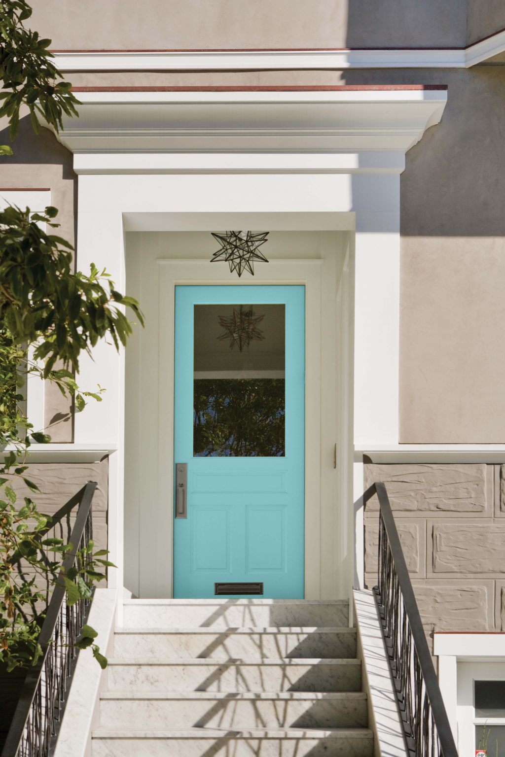L'extérieur d'une maison avec la porte d'entrée peinte dans la couleur Pur turquoise