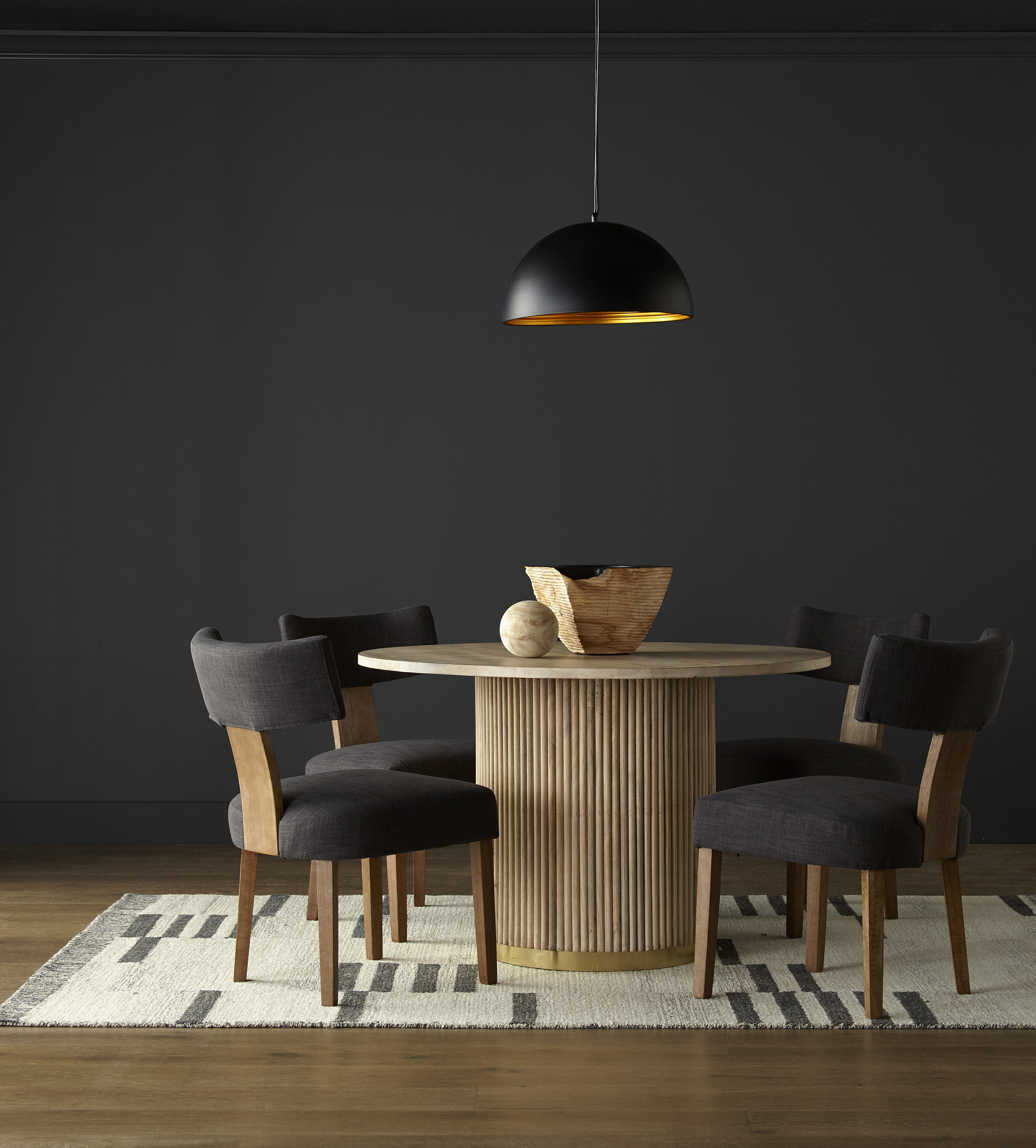 Une salle à manger simple et élégante avec des murs dans la couleur Poivre concassé, agrémentée d'une suspension noire
