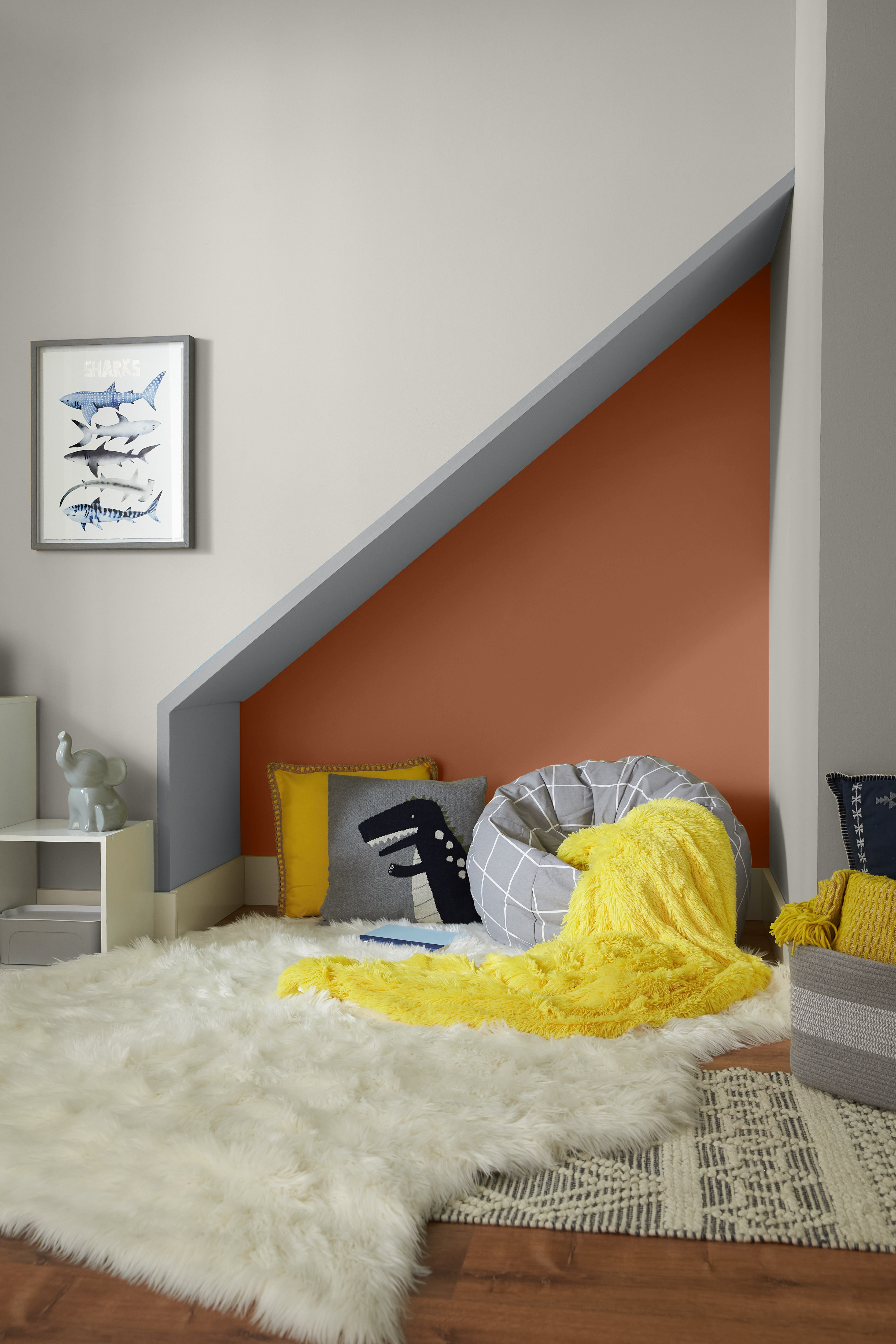 Une chambre d'enfant avec des murs dans la couleur Gris gratifiant et un petit coin dans la couleur Flambé à l’orange