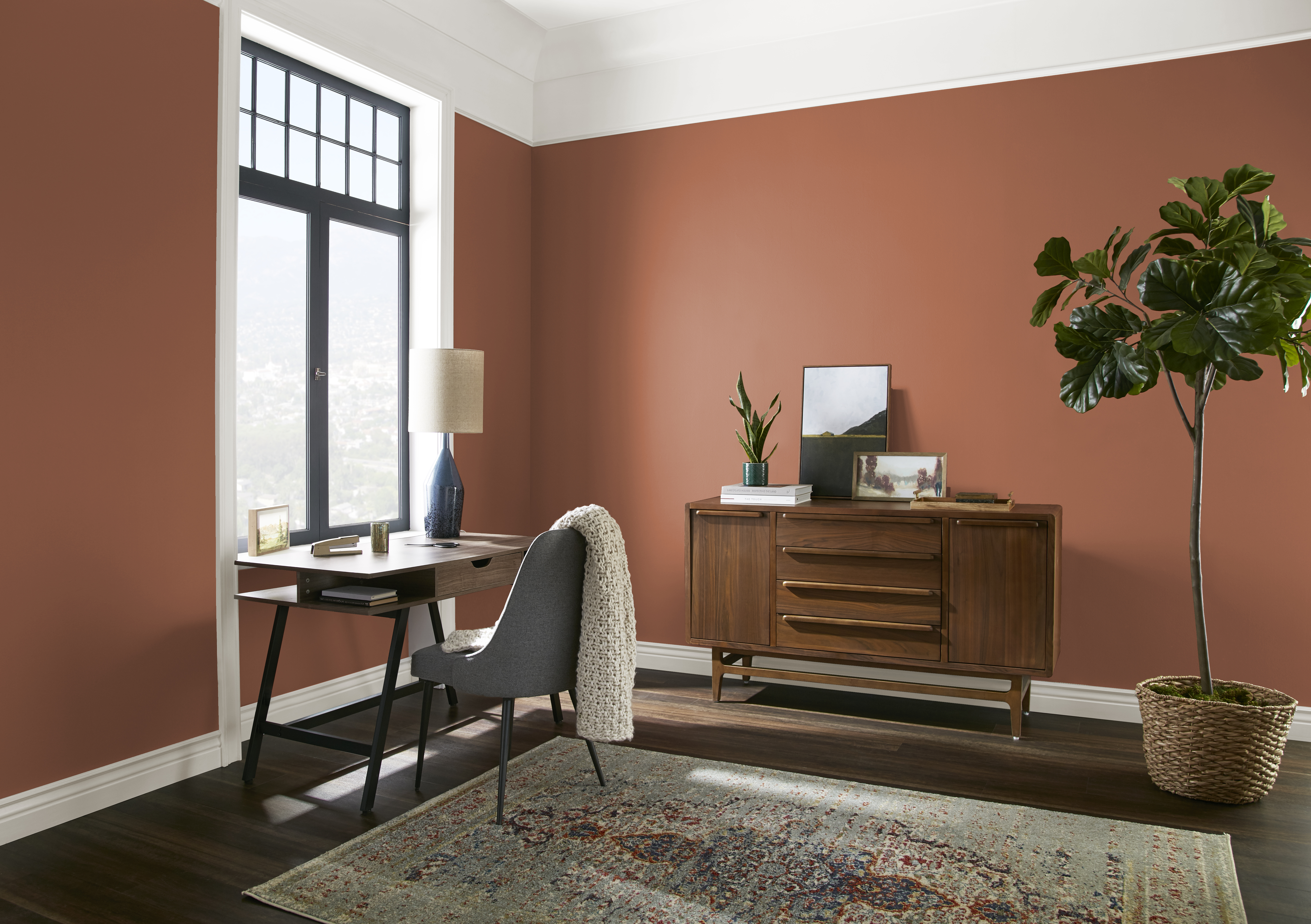 Une pièce aux murs peints en Flambé à l’orange décorée avec des meubles neutres de style années 50 
