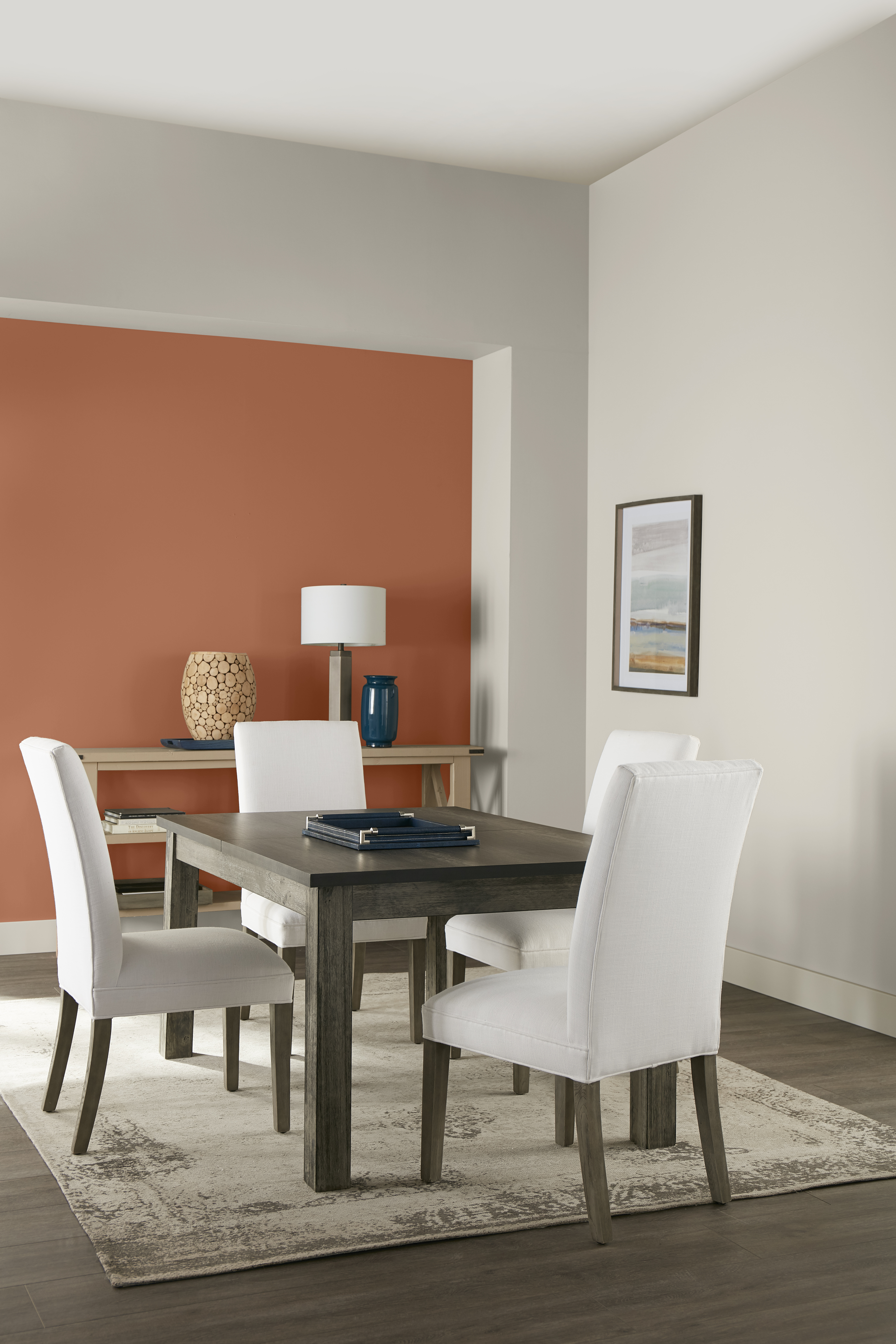 Une salle à manger simple et élégante avec des murs de couleur Gris tranquille et un mur d'accent de couleur Flambé à l’orange