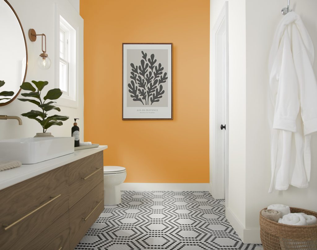 Une salle de bain moderne avec un mur d'accent jaune joyeux et un sol carrelé géométrique noir et blanc