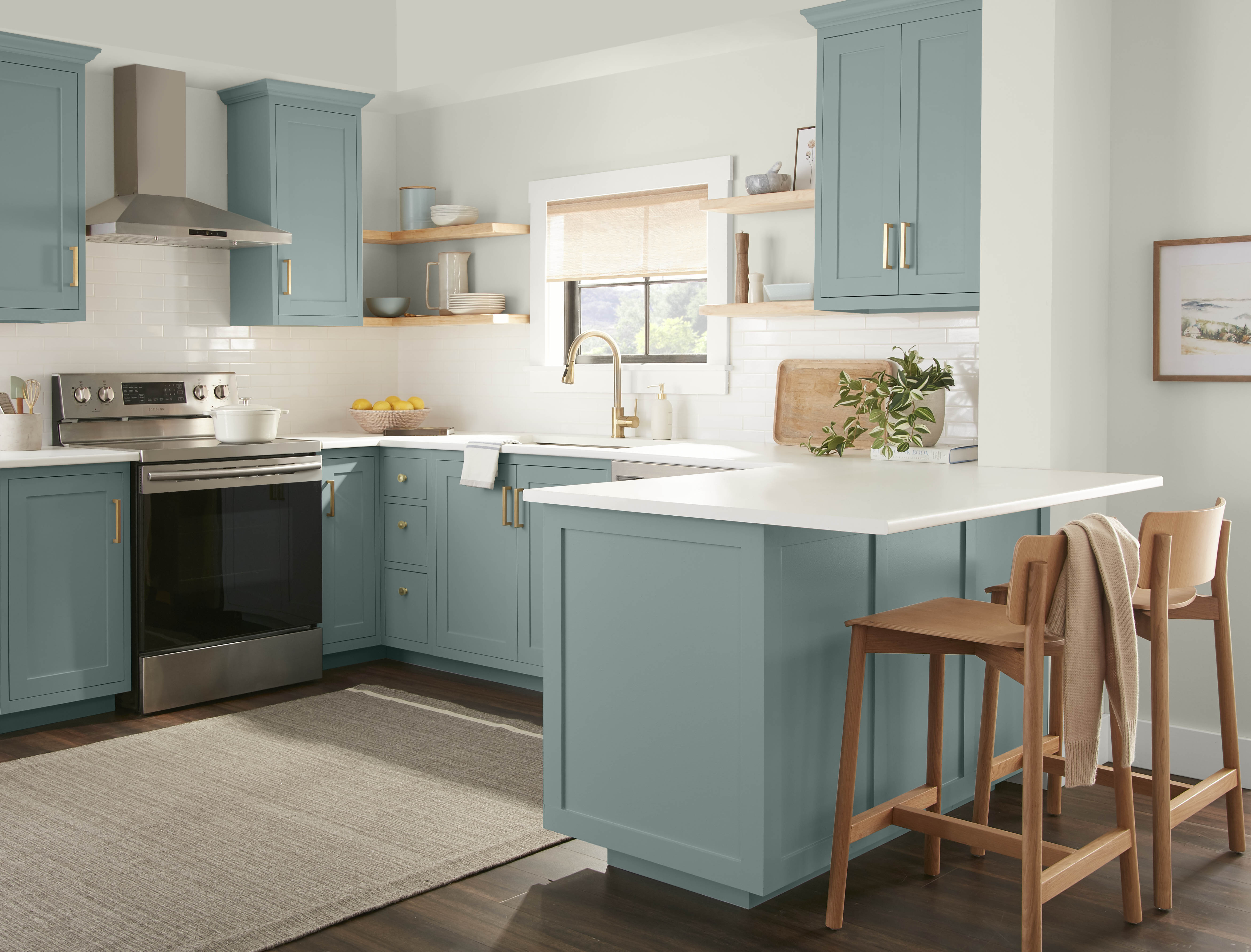 Une cuisine d'un blanc éclatant avec les armoires peintes dans une couleur bleu-vert poudreux