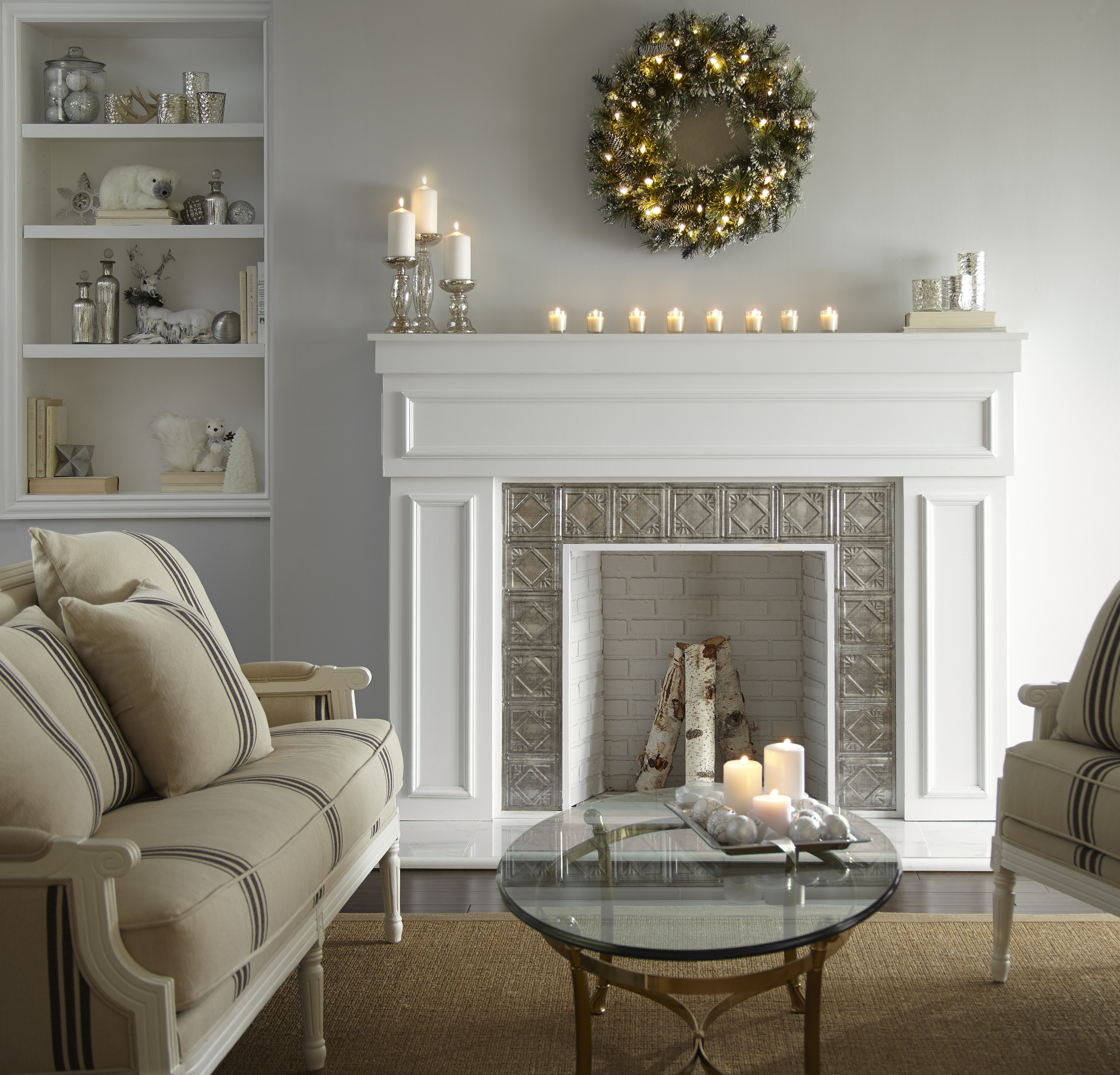 Un salon blanc avec un foyer blanc décoré d'une couronne de Noël et de bougies 