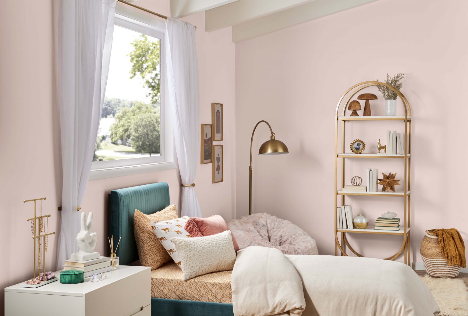Une chambre d'adolescent avec des murs peints dans une couleur rose clair neutre, stylisée avec des accents décoratifs neutres et or métallique