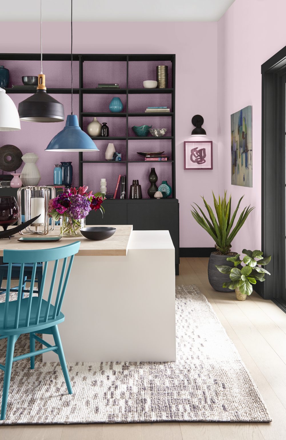 Une salle à manger avec des murs peints en rose-lavande et des armoires encastrées noires