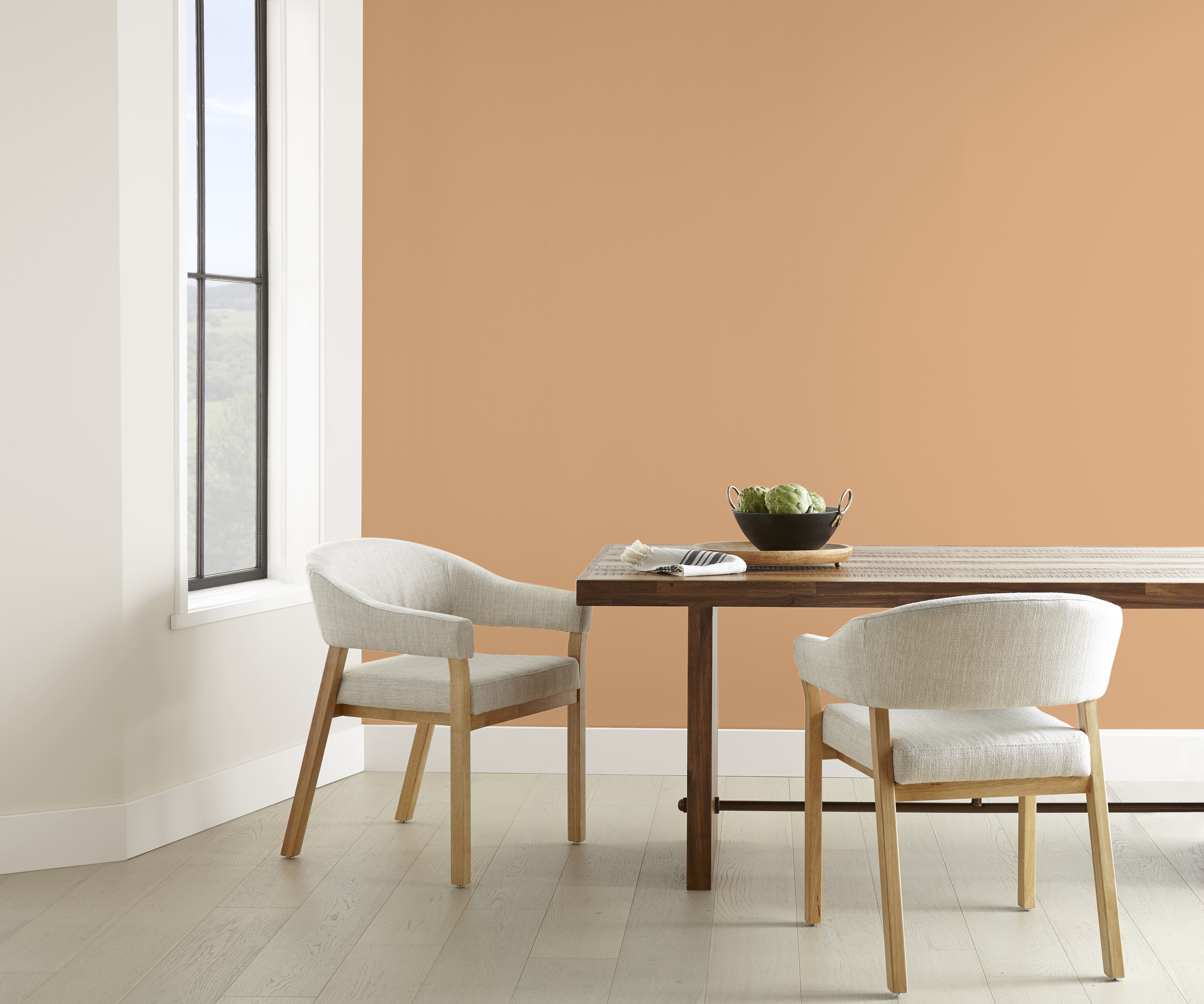 Une salle à manger minimaliste avec un mur d'accent peint dans une couleur de brun doré