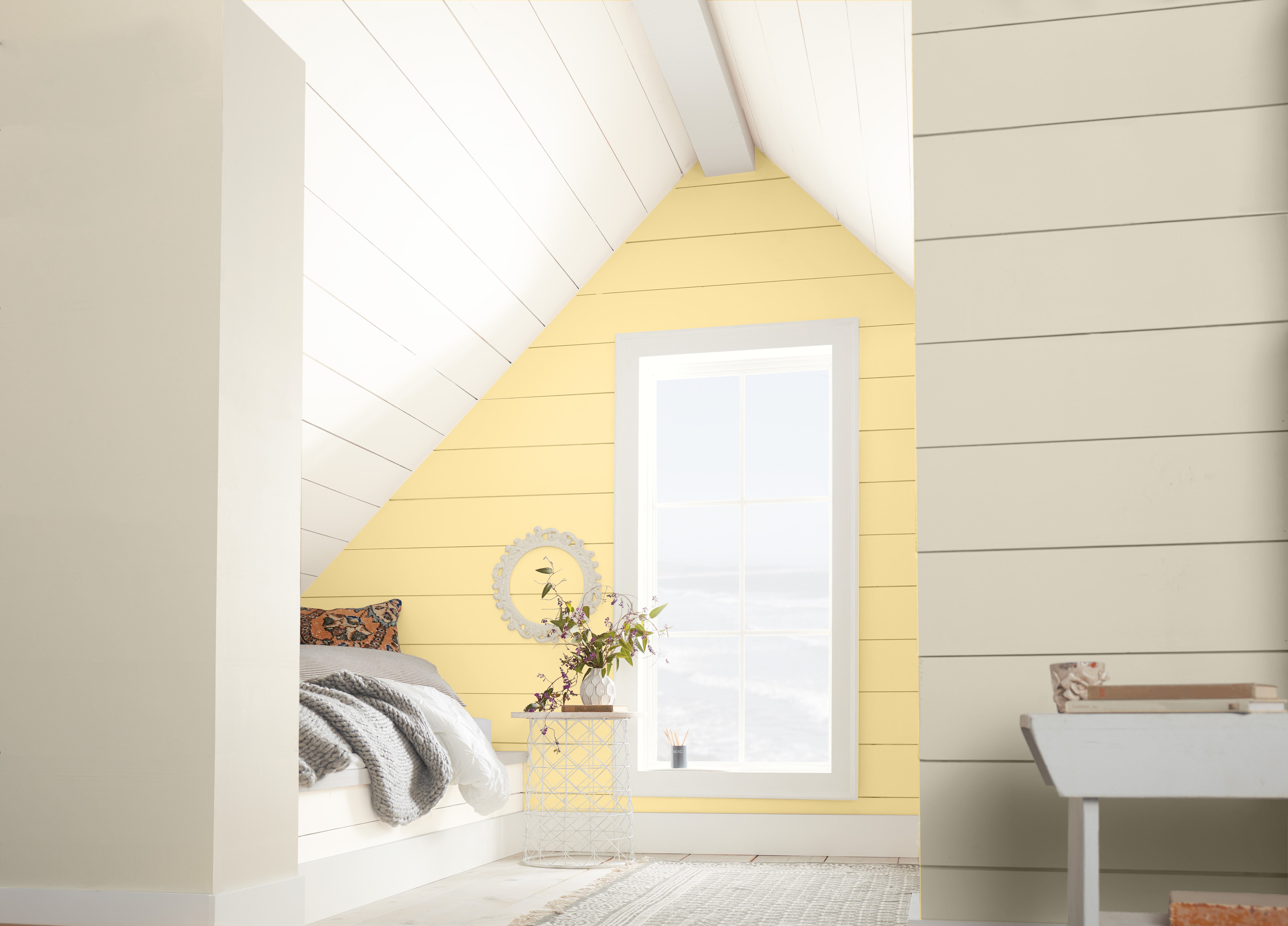 Une chambre à coucher blanche avec un mur d'accent peint dans une couleur jaune pastel 