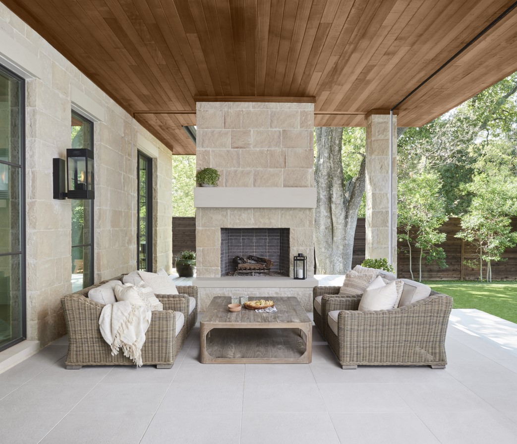 Un luxueux salon extérieur avec une cheminée et un plafond en bois brun semi-transparent