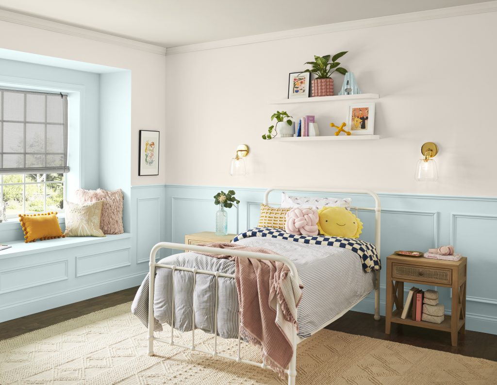 Une chambre d'enfant avec les murs du bas et l’alcôve de fenêtre peints en bleu pâle