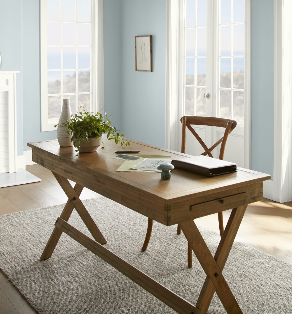 Un bureau à domicile lumineux avec des murs peints en bleu pâle