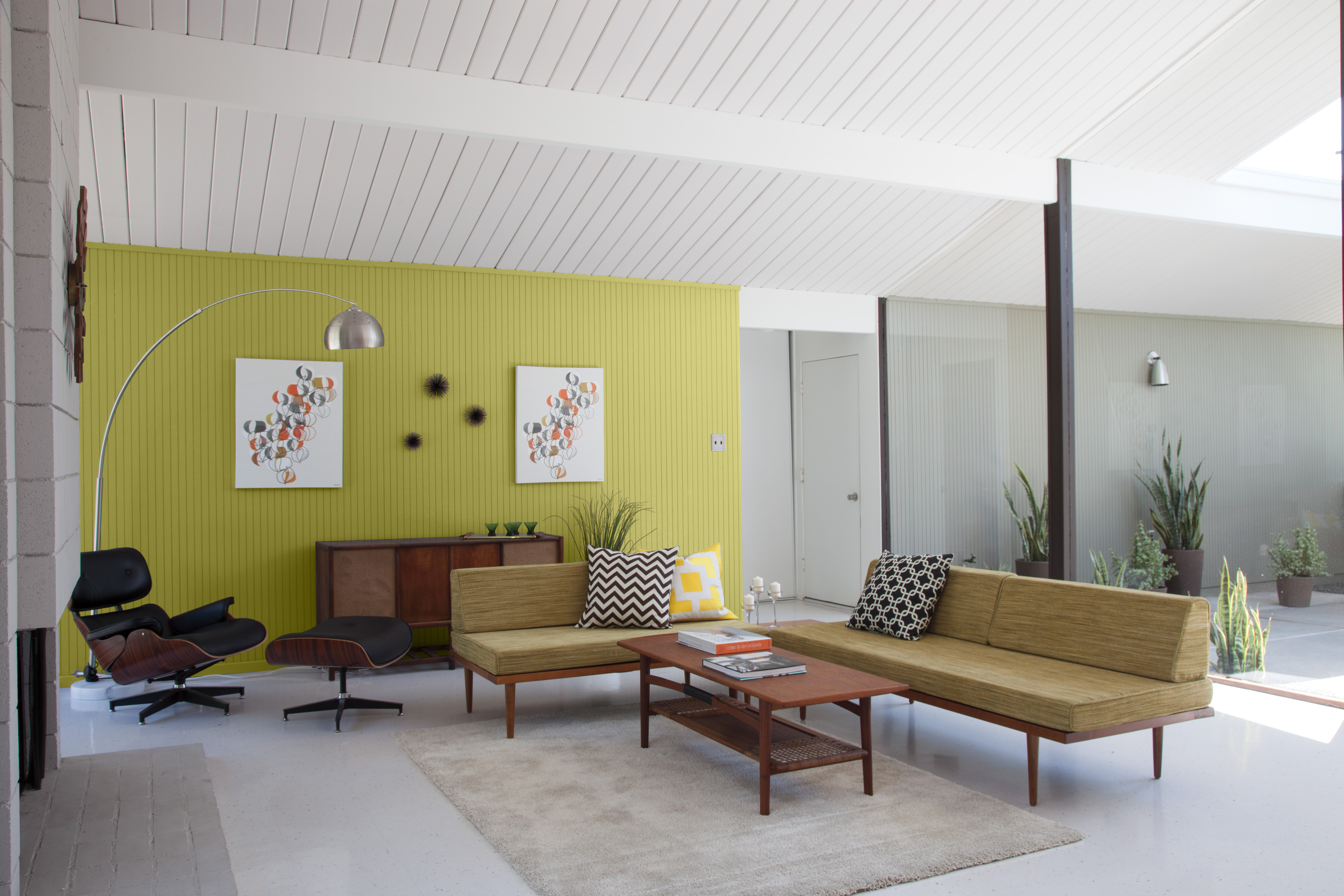 Un espace de vie moderne d’inspiration années 50 avec un mur d'accent peinturé dans un jaune-vert vibrant