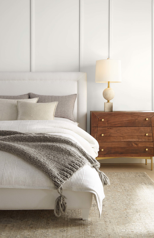 Une chambre contemporaine avec un lit confortable et des murs d'un blanc légèrement teinté de jaune, ce qui ajoute une touche chaleureuse et accueillante à l'espace.