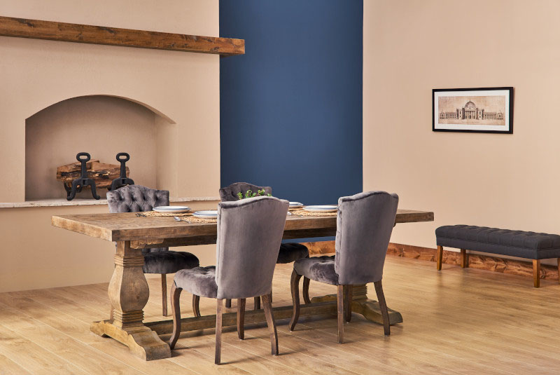 Salle à manger avec foyer, table en bois et chaises.