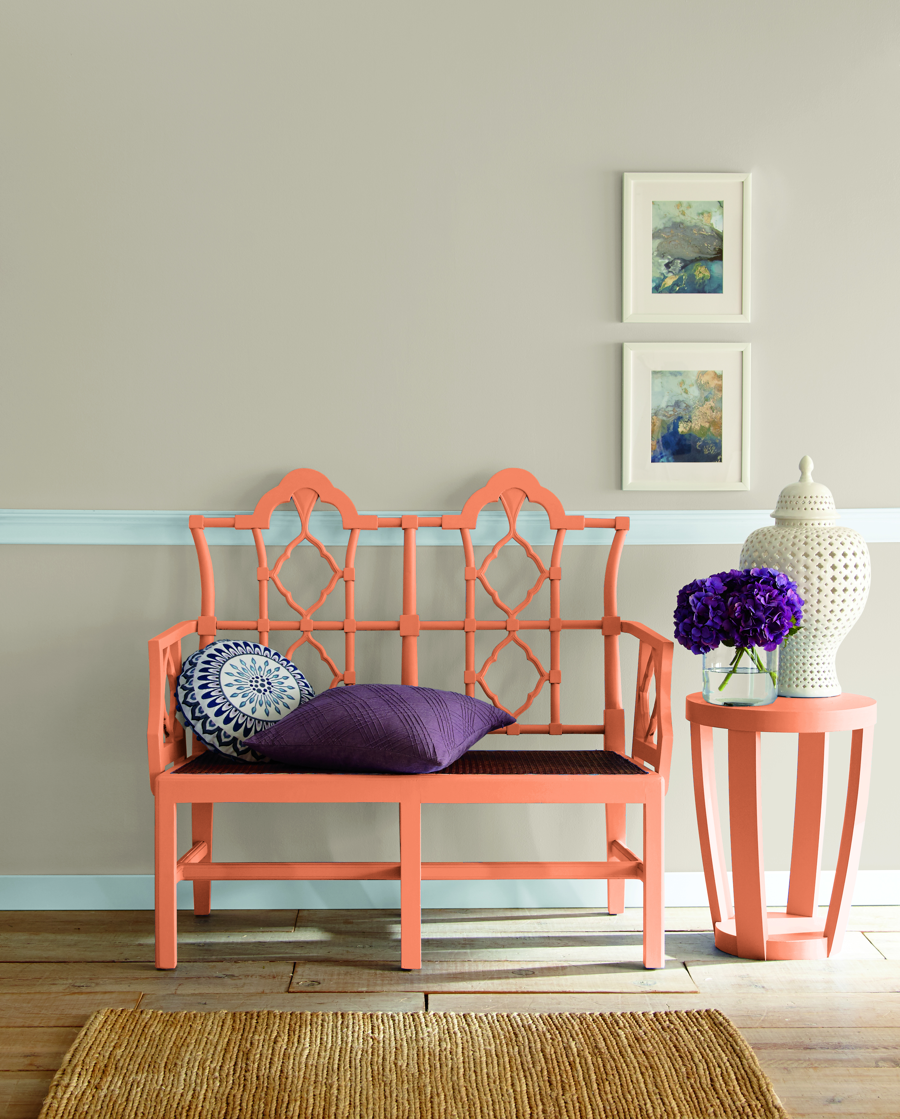 Cette image montre un couloir avec un banc et une table d’appoint peints en orange.