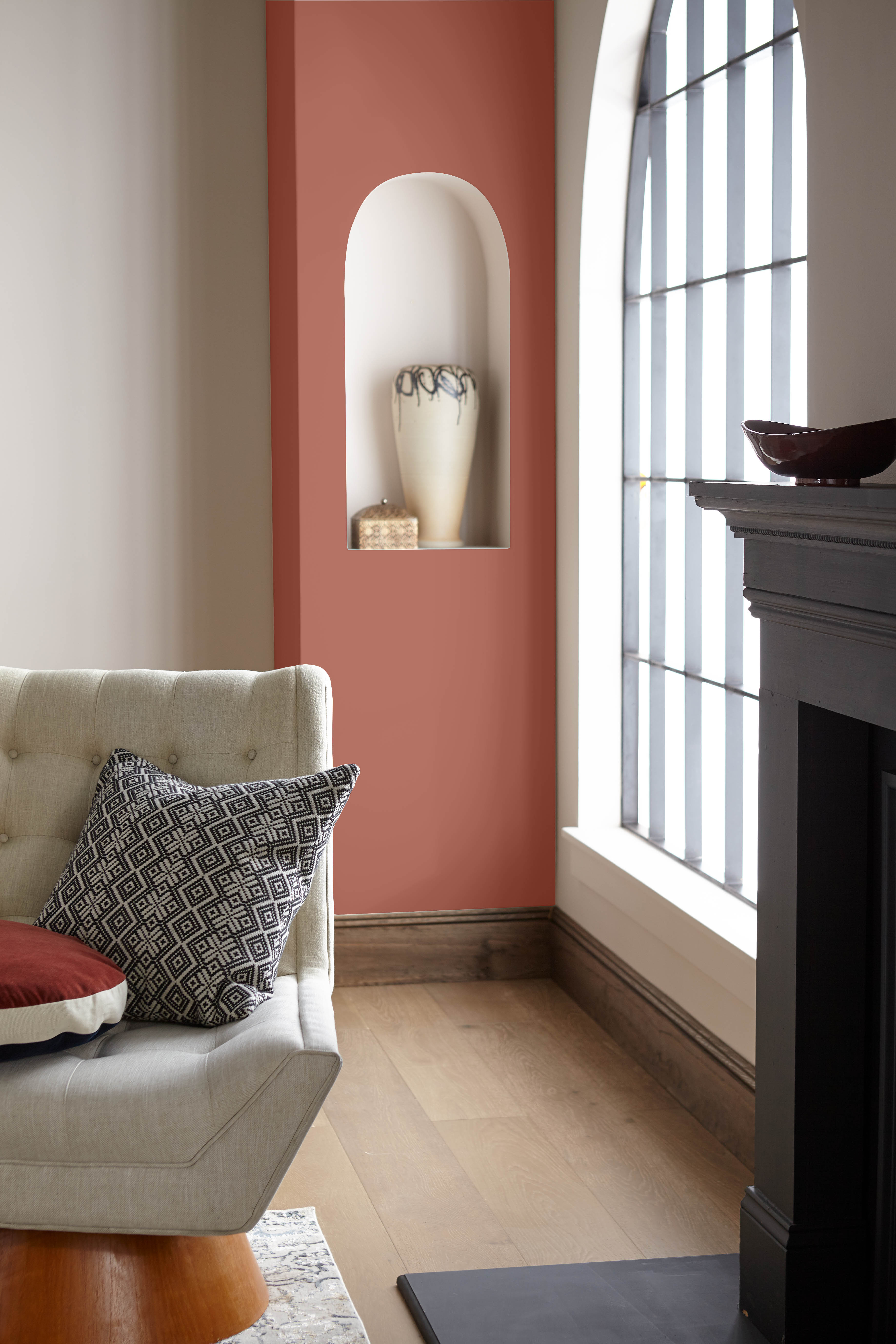 Cette image montre un salon avec un manteau de cheminée et une colonne de coin de couleur terre cuite.