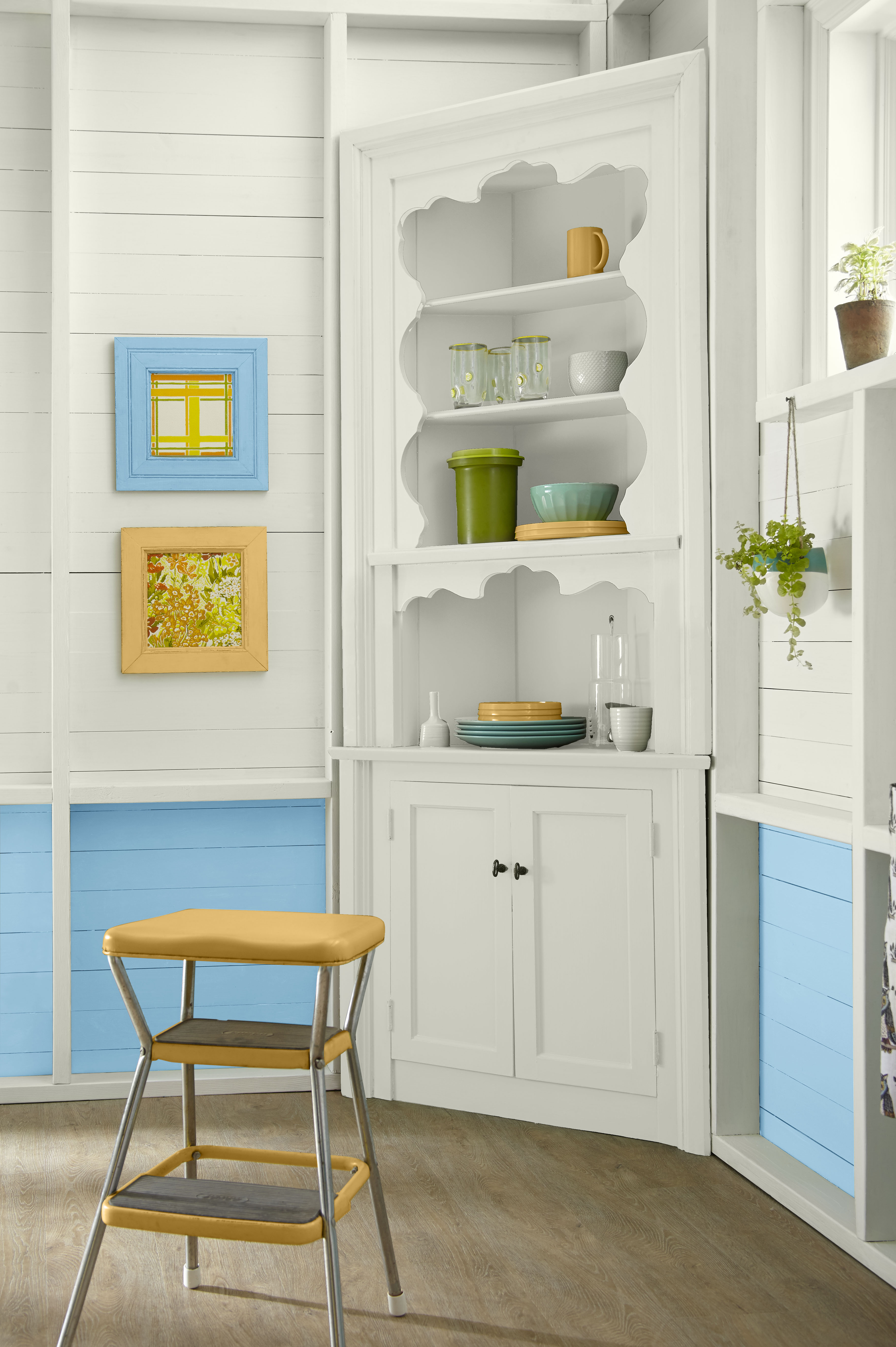 Cette image montre un coin-déjeuner peint en blanc avec un bel accent de bleu pâle céleste, qui éclaircit la pièce et encadre doucement les détails architecturaux.