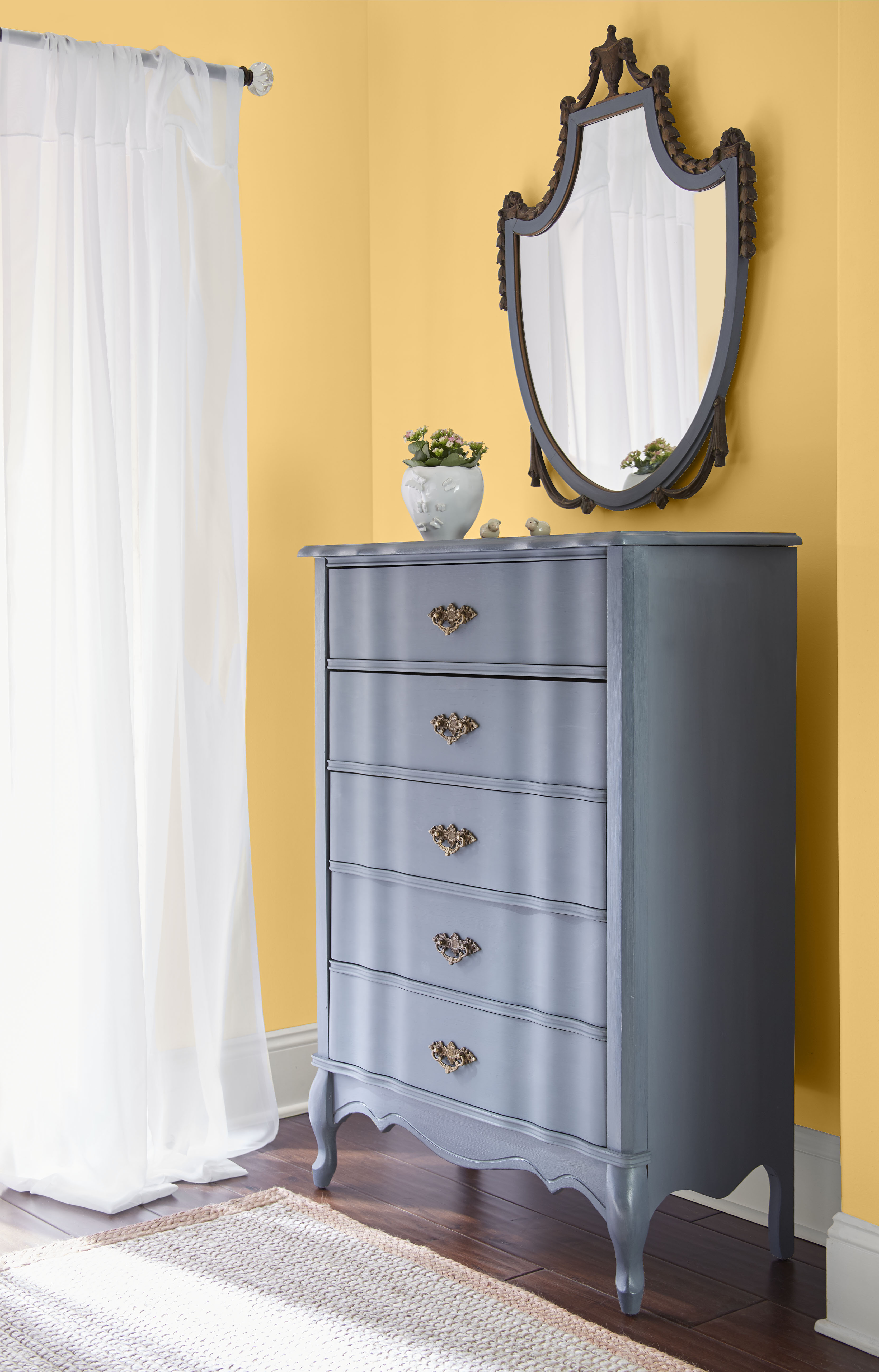 Cette image montre une chambre à coucher dont les murs jaune moutarde créent un effet de dorure qui anoblit et dynamise la pièce.