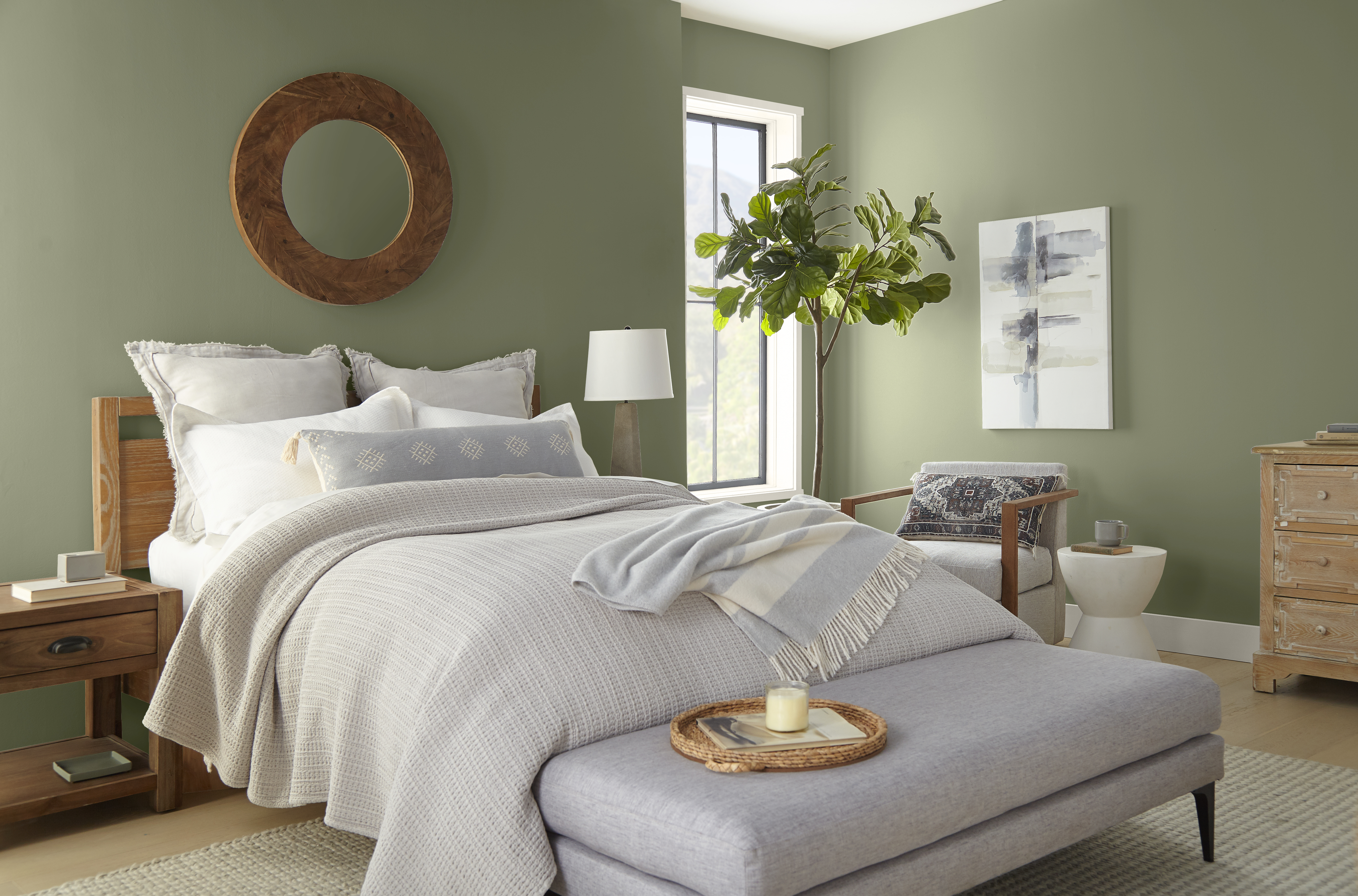 Cette image montre une chambre reposante dont les murs en teinte Écologique entourent un lit doté d’une tête en bois blond et décoré d’oreillers et de traversins blancs, le tout assorti d’une literie neutre à plusieurs épaisseurs, d’un banc de lit rembourré et d’éléments d’accent en matières naturelles.